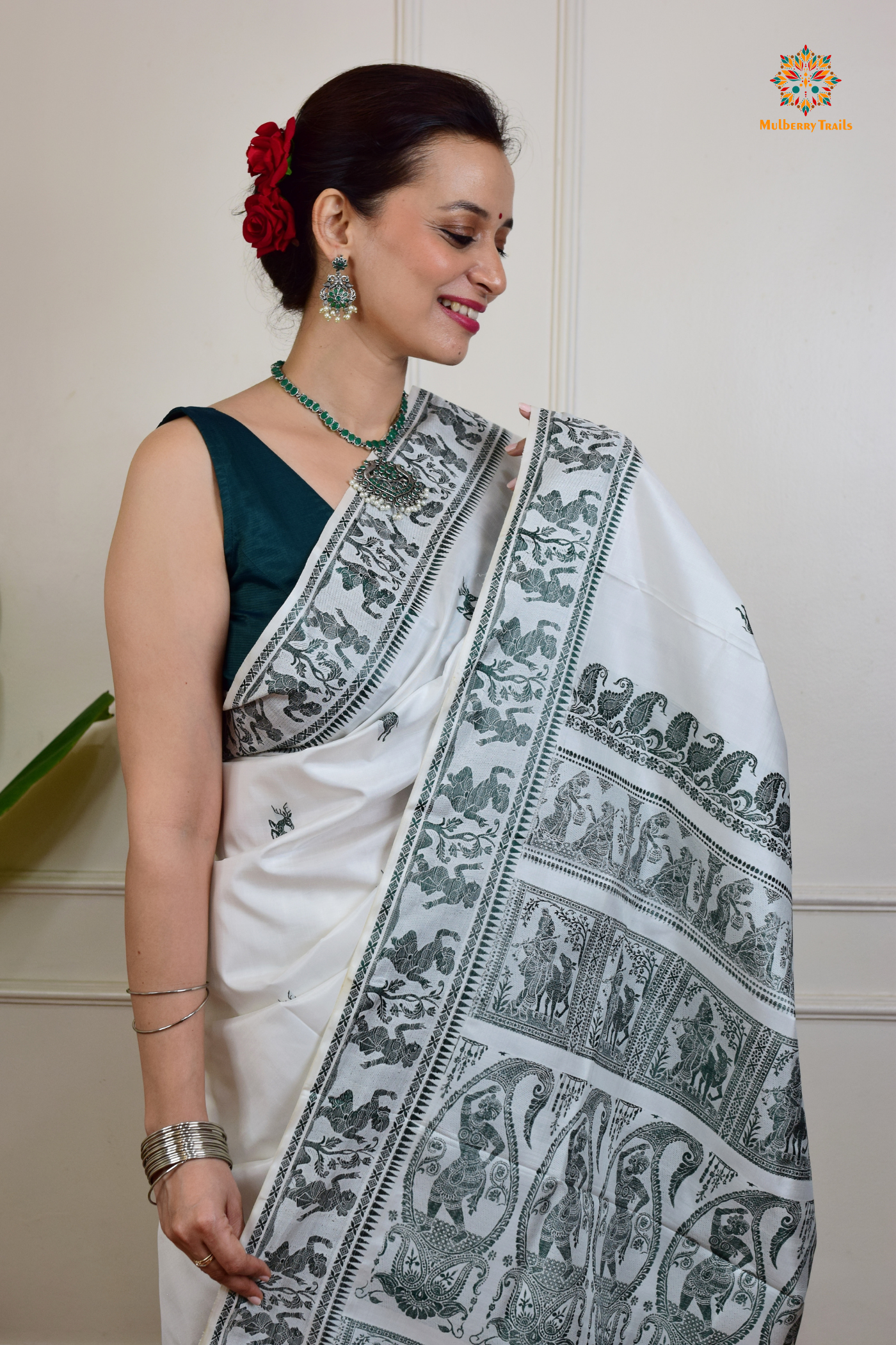 A woman wearing a White Baluchari Pure SIlk saree. White baluchari silk , bengal silk saree with deer motif on pallu and ramayan, mahabharat motifs on pallu. This is a soft pure silk saree suitable for weddings, parties, festivities. suitable for Durga Puja shopping enthusiasts and diwali festival.