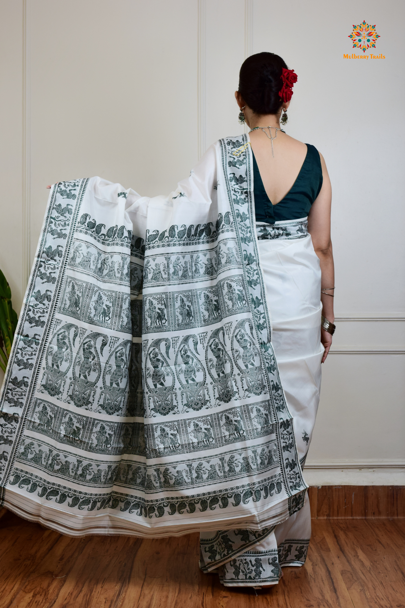 A woman wearing a White Baluchari Pure SIlk saree. White baluchari silk , bengal silk saree with deer motif on pallu and ramayan, mahabharat motifs on pallu. This is a soft pure silk saree suitable for weddings, parties, festivities. suitable for Durga Puja shopping enthusiasts and diwali festival.