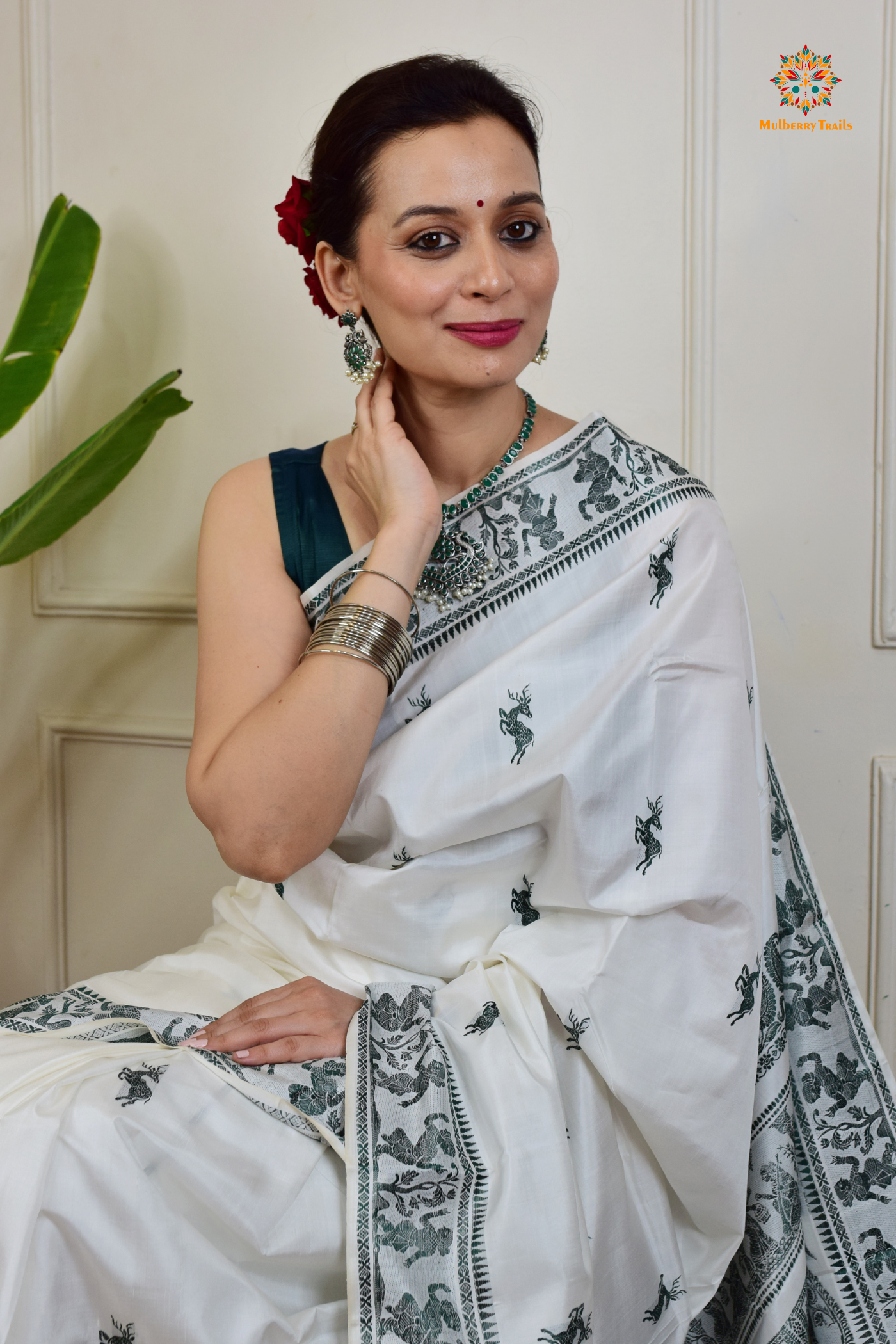 A woman wearing a White Baluchari Pure SIlk saree. White baluchari silk , bengal silk saree with deer motif on pallu and ramayan, mahabharat motifs on pallu. This is a soft pure silk saree suitable for weddings, parties, festivities. suitable for Durga Puja shopping enthusiasts and diwali festival.