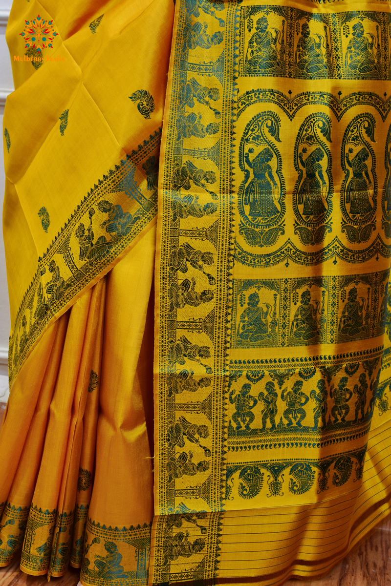 A woman wearing a Yellow Baluchari Pure SIlk saree. purple baluchari silk , bengal silk saree with deer motif on pallu and ramayan, mahabharat motifs on pallu. This is a soft pure silk saree suitable for weddings, parties, festivities. suitable for Durga Puja shopping enthusiasts and diwali festival. 