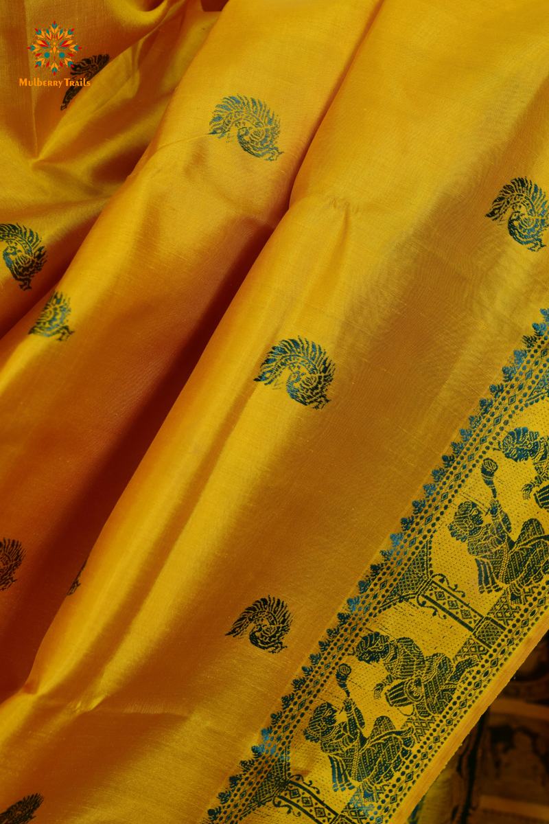 A woman wearing a Yellow Baluchari Pure SIlk saree. purple baluchari silk , bengal silk saree with deer motif on pallu and ramayan, mahabharat motifs on pallu. This is a soft pure silk saree suitable for weddings, parties, festivities. suitable for Durga Puja shopping enthusiasts and diwali festival. 