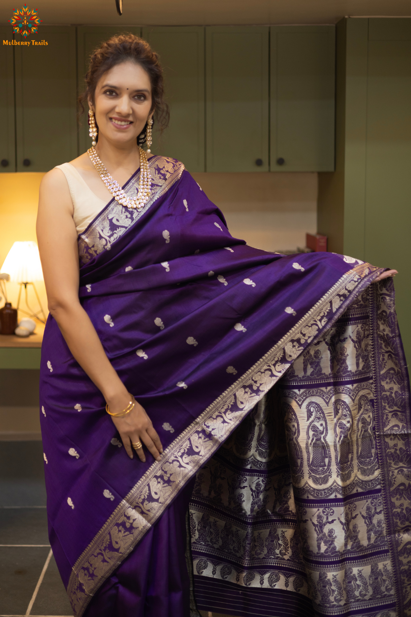 Woman wearing a traditional baluchari saree in a room with a desk and lamp. Woman in a carrot red and silver resham work saree standing indoors with a desk and lamp in the background.

Baluchari – Pure Silk Baluchari Saree

1. “Pure silk Baluchari saree with temple motif weave and Silver resham detailing for a regal look.”

2. “Silk Mark pure silk saree featuring intricate gold resham work motifs and rich texture. 