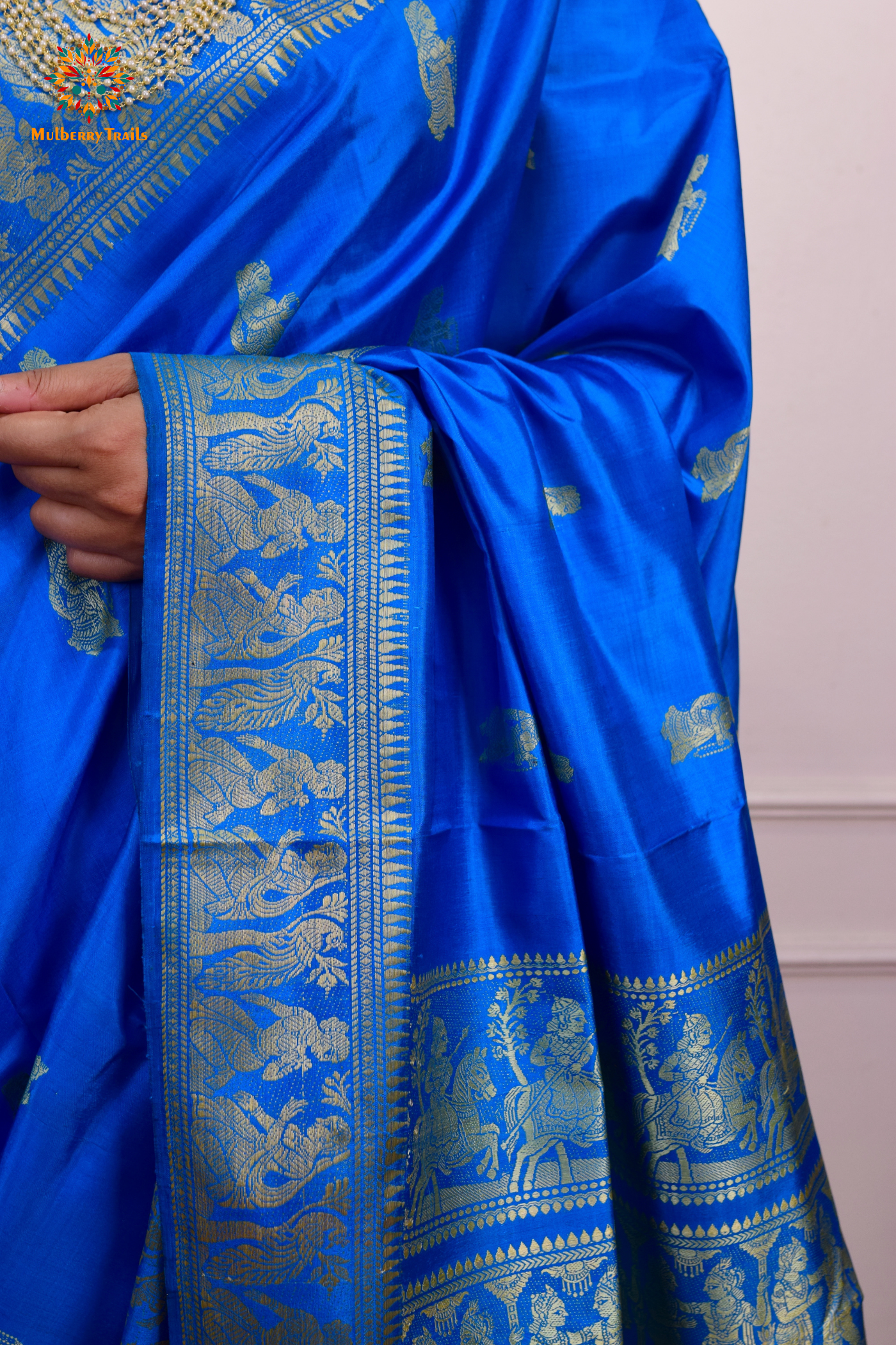 A woman wearing a Blue Baluchari Pure SIlk saree. Blue baluchari silk , bengal silk saree with deer motif on pallu and ramayan, mahabharat motifs on pallu. This is a soft pure silk saree suitable for weddings, parties, festivities. suitable for Durga Puja shopping enthusiasts and diwali festival. 