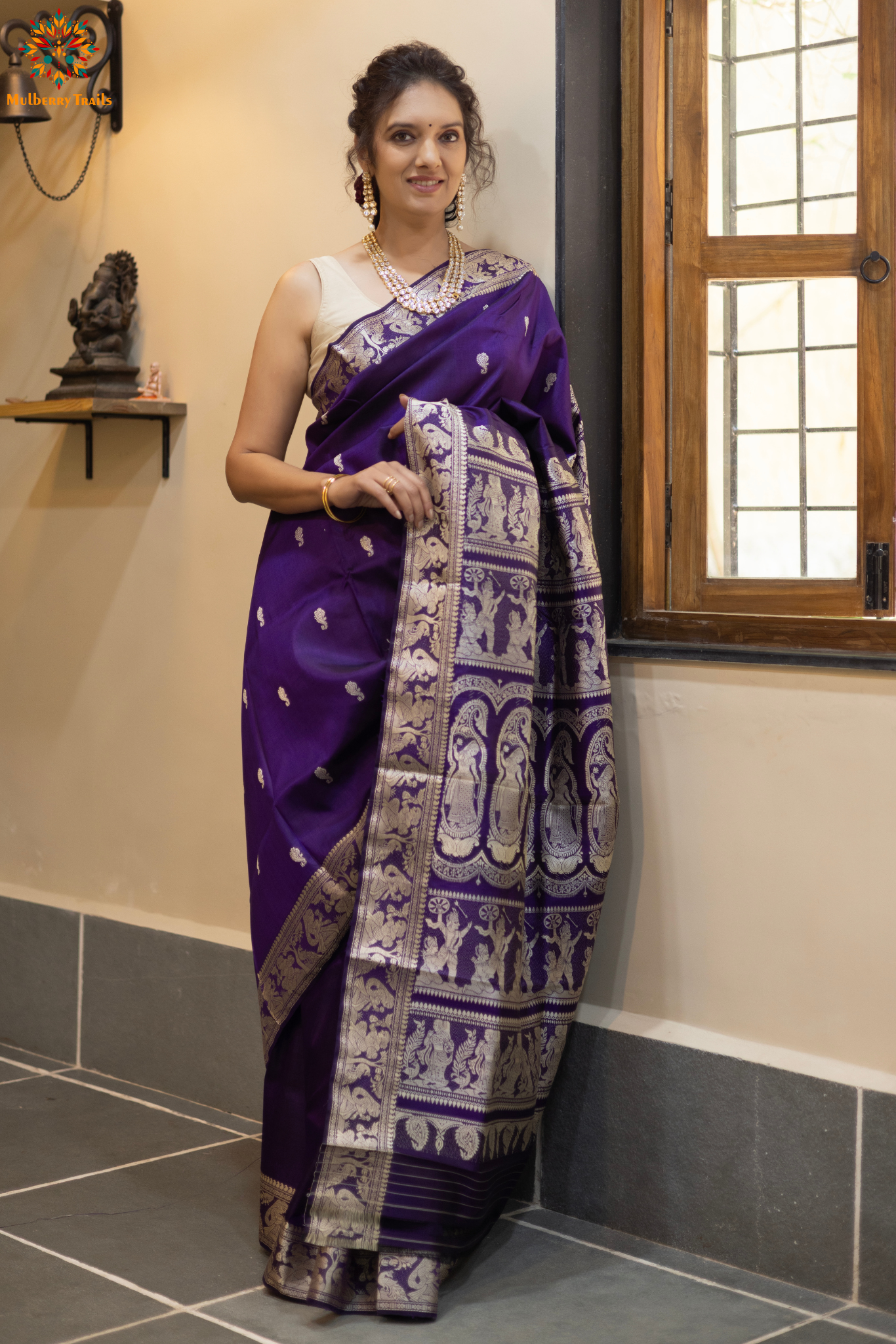 Woman wearing a traditional baluchari saree in a room with a desk and lamp. Woman in a carrot red and silver resham work saree standing indoors with a desk and lamp in the background.

Baluchari – Pure Silk Baluchari Saree

1. “Pure silk Baluchari saree with temple motif weave and Silver resham detailing for a regal look.”

2. “Silk Mark pure silk saree featuring intricate gold resham work motifs and rich texture. 
