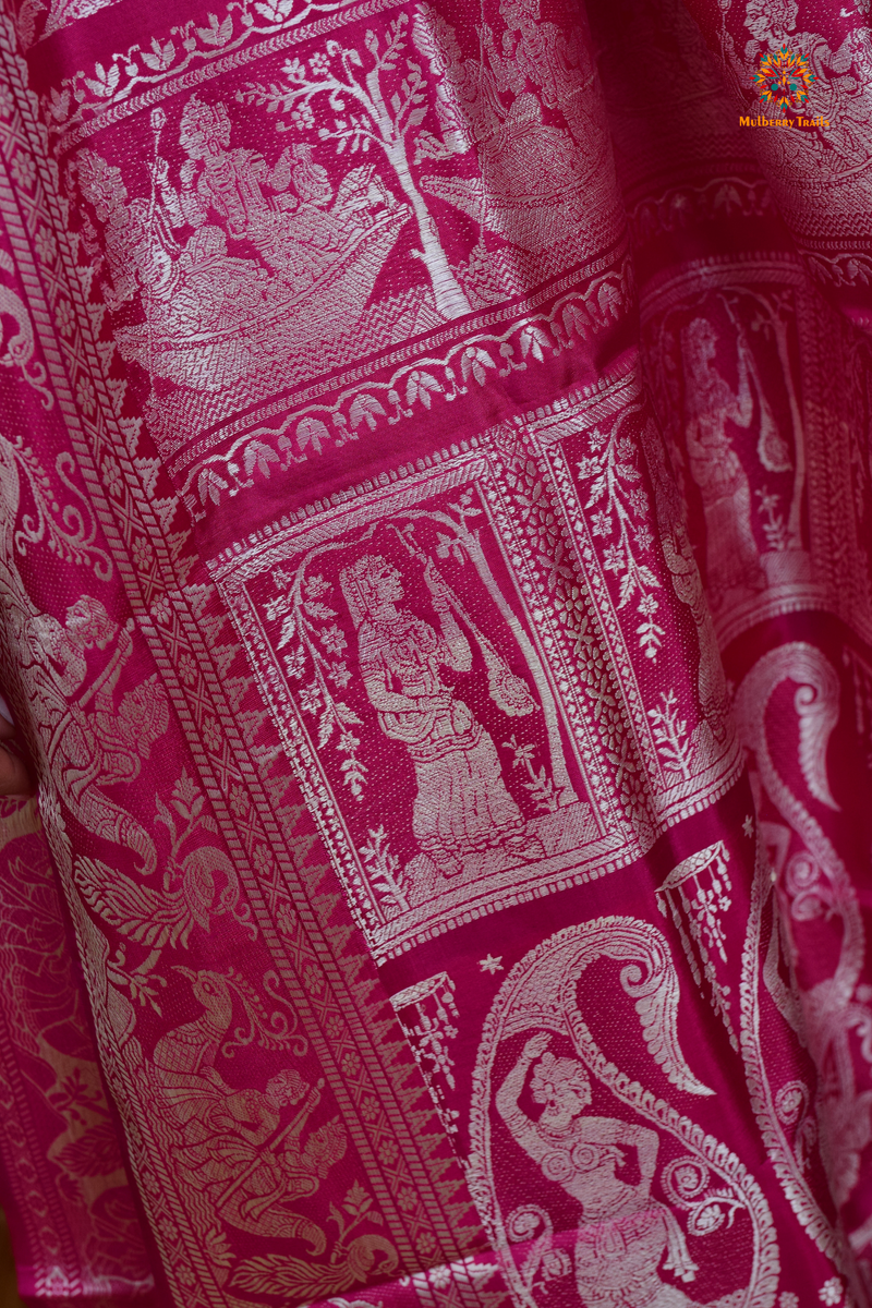 A woman wearing a Pink Baluchari Pure SIlk saree. Pink baluchari silk , bengal silk saree with deer motif on pallu and ramayan, mahabharat motifs on pallu. This is a soft pure silk saree suitable for weddings, parties, festivities. suitable for Durga Puja shopping enthusiasts and diwali festival. 