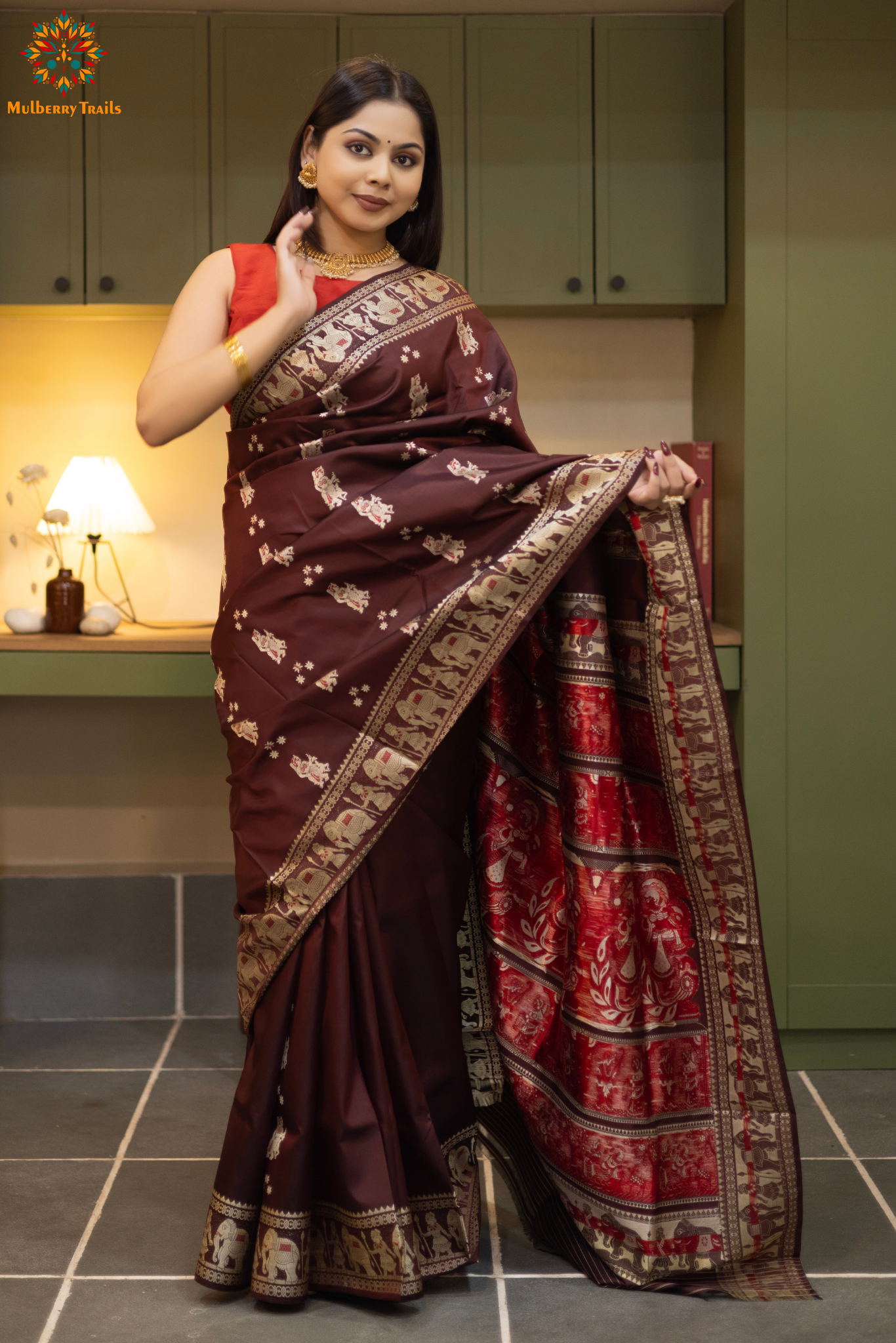 Woman in a Coffee brown and silver resham work saree standing indoors with a desk and lamp in the background.
Woman wearing a Coffee brown saree with a pattern in a elegant setting. 

Baluchari – Pure Silk Meenakari Saree

1. “Pure silk Baluchari Meenakari saree with meenakari motif weave and Silver resham detailing for a regal look.”

2. “Silk Mark pure silk meenakari saree featuring intricate gold resham work motifs and rich texture.” 