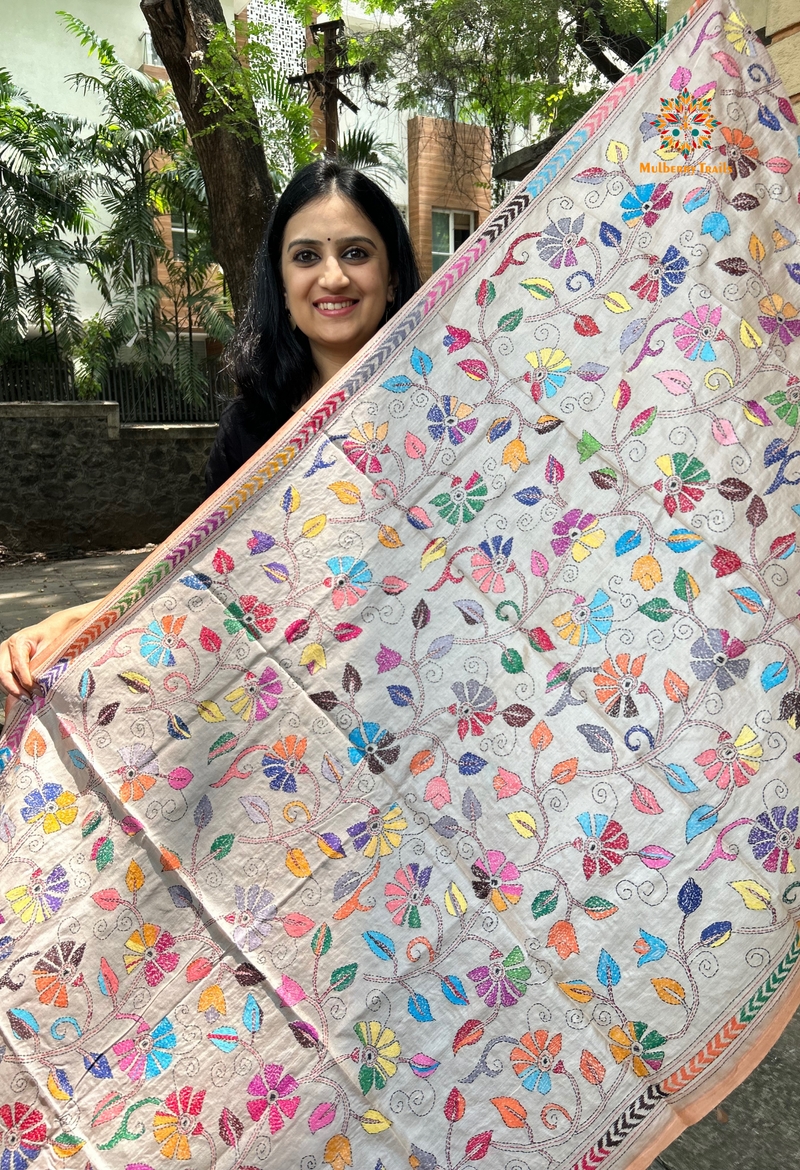 Elegant pure silk dupatta in beige color, featuring intricate Kantha embroidery with vibrant floral and paisley motifs. The dupatta boasts a luxurious sheen and a rich texture, perfect for adding a touch of sophistication to any outfit. The hand-embroidered details highlight the traditional craftsmanship and artistry, making it a statement accessory for festive occasions or special events.