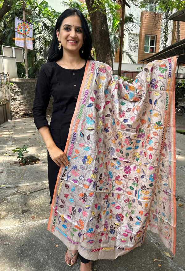 Elegant pure silk dupatta in beige color, featuring intricate Kantha embroidery with vibrant floral and paisley motifs. The dupatta boasts a luxurious sheen and a rich texture, perfect for adding a touch of sophistication to any outfit. The hand-embroidered details highlight the traditional craftsmanship and artistry, making it a statement accessory for festive occasions or special events.