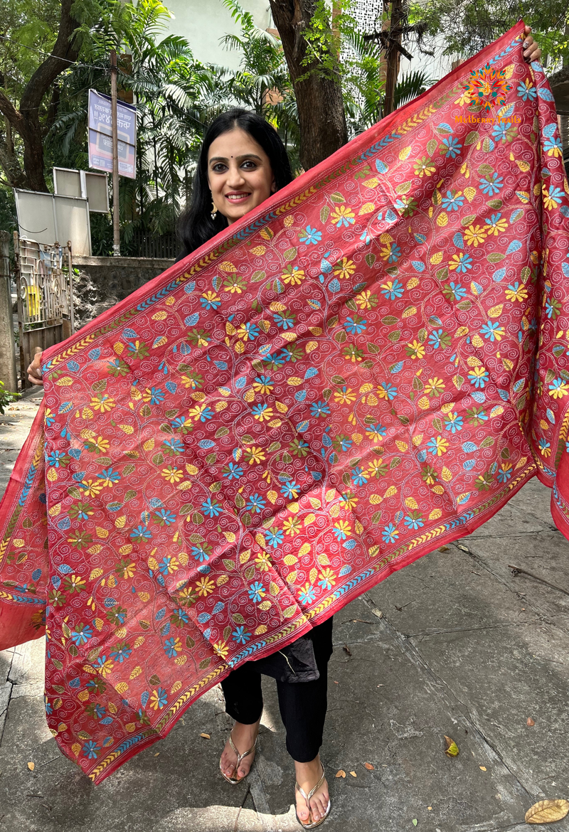 Elegant pure silk dupatta in peach Orange color, featuring intricate Kantha embroidery with vibrant floral and paisley motifs. The dupatta boasts a luxurious sheen and a rich texture, perfect for adding a touch of sophistication to any outfit. The hand-embroidered details highlight the traditional craftsmanship and artistry, making it a statement accessory for festive occasions or special events.