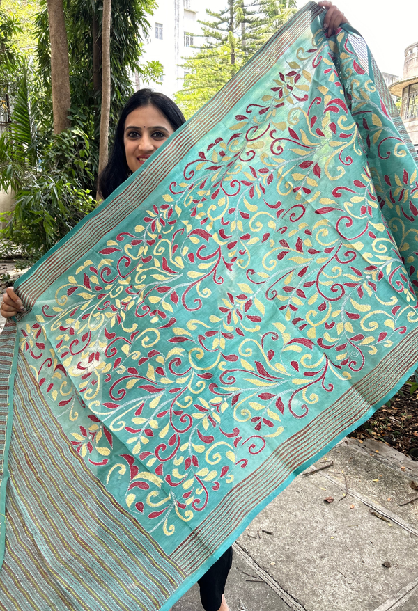 Elegant pure silk dupatta in Green color, featuring intricate Floral Kantha embroidery with vibrant floral and paisley motifs. The dupatta boasts a luxurious sheen and a rich texture, perfect for adding a touch of sophistication to any outfit. The hand-embroidered details highlight the traditional craftsmanship and artistry, making it a statement accessory for festive occasions or special events.