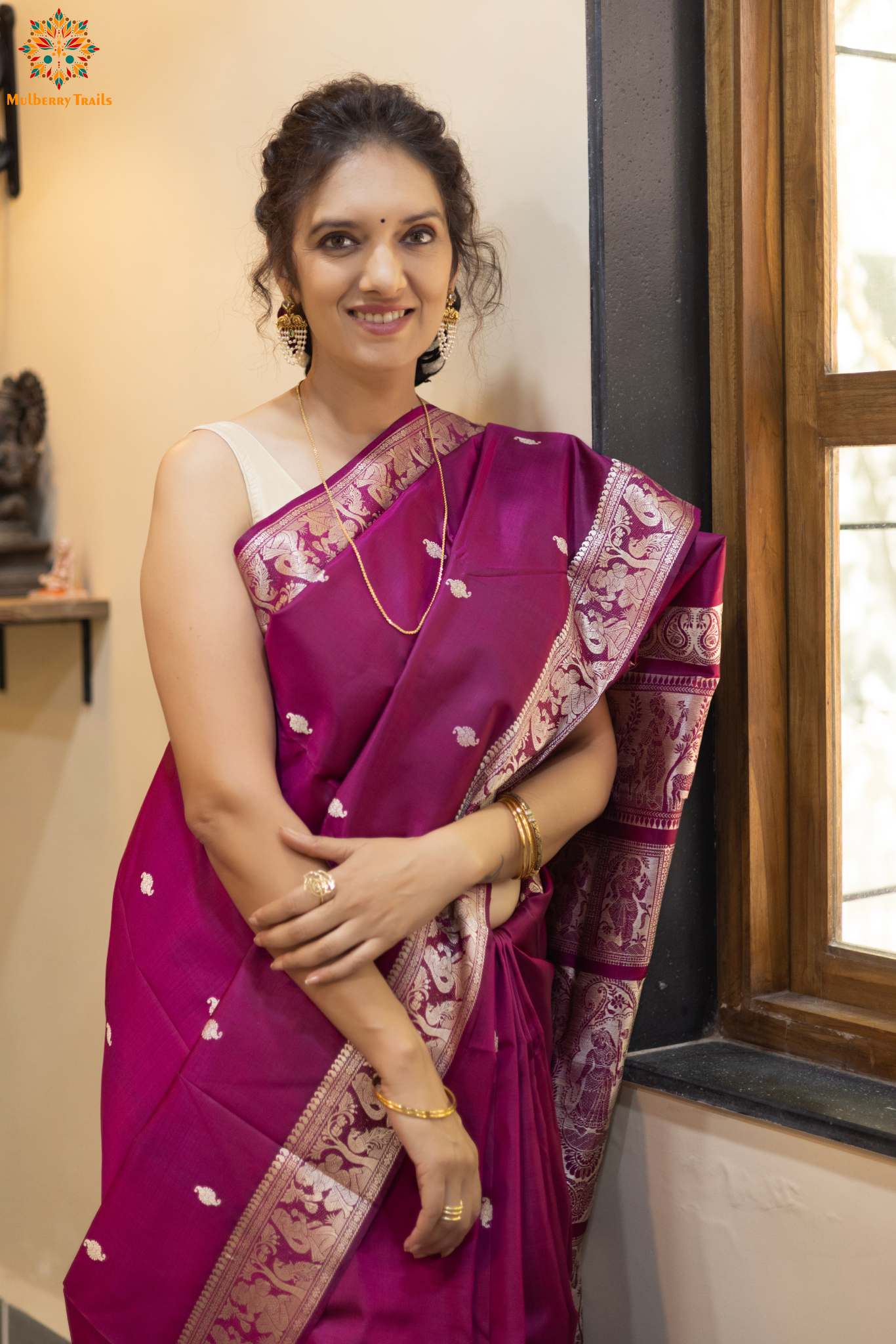 Woman wearing a traditional baluchari saree in a room with a desk and lamp. Woman in a carrot red and silver resham work saree standing indoors with a desk and lamp in the background.

Baluchari – Pure Silk Baluchari Saree

1. “Pure silk Baluchari saree with temple motif weave and Silver resham detailing for a regal look.”

2. “Silk Mark pure silk saree featuring intricate gold resham work motifs and rich texture. 