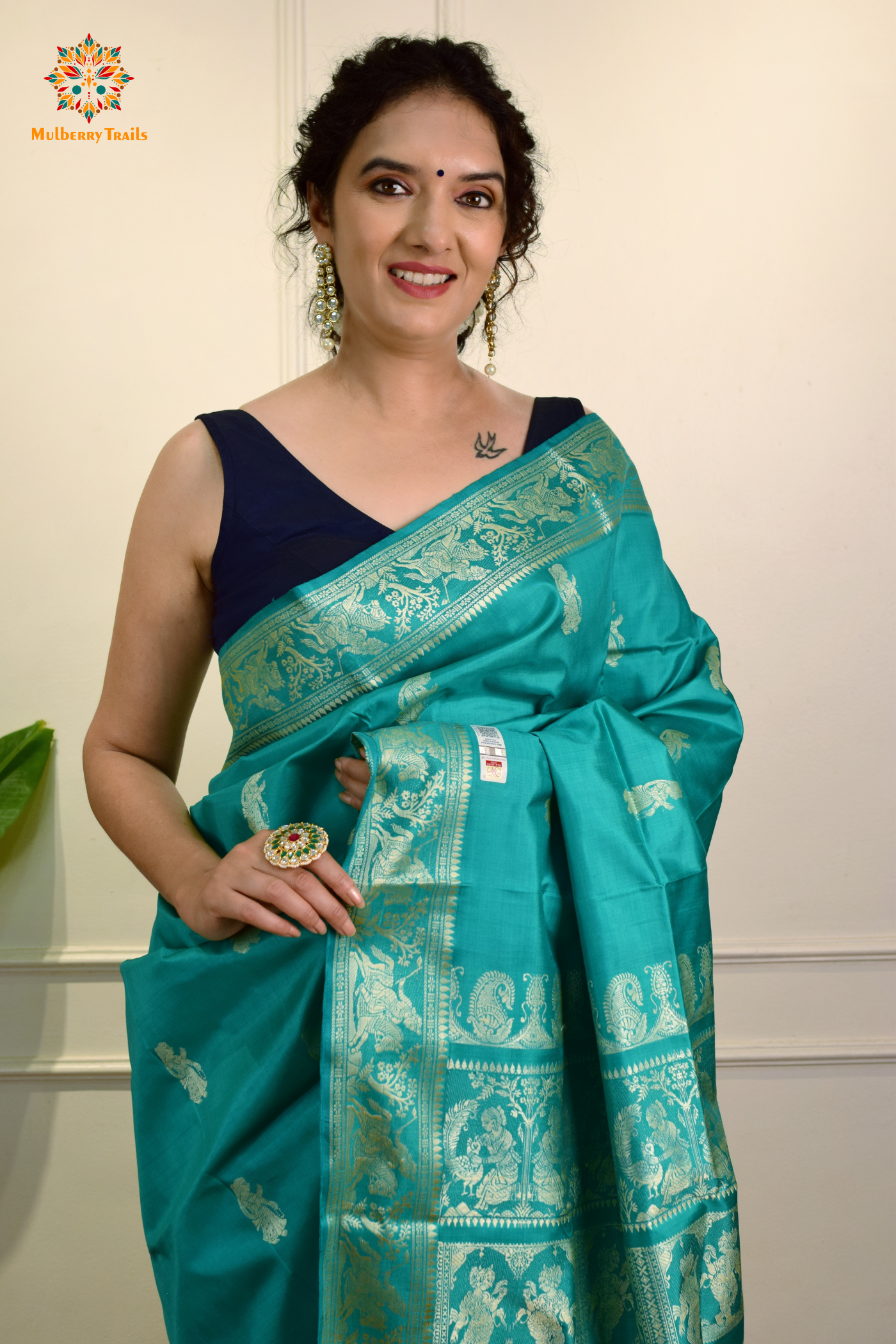 A woman wearing a Purple Baluchari Pure SIlk saree. purple baluchari silk , bengal silk saree with deer motif on pallu and ramayan, mahabharat motifs on pallu. This is a soft pure silk saree suitable for weddings, parties, festivities. suitable for Durga Puja shopping enthusiasts and diwali festival. 