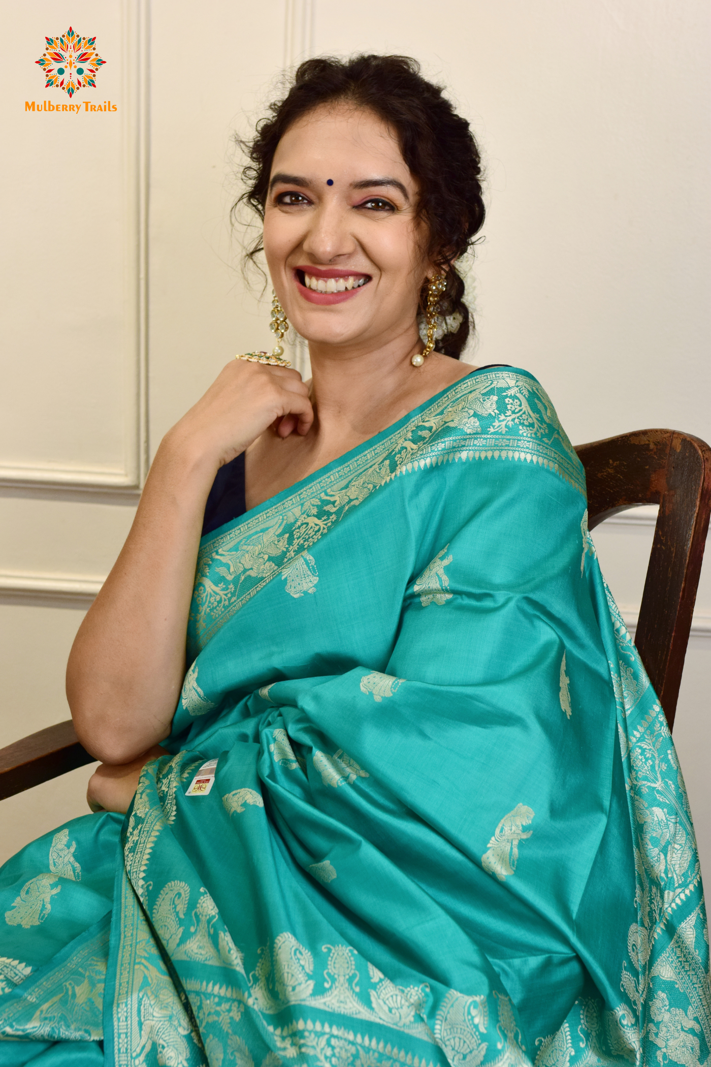 A woman wearing a Aqua Blue Baluchari Pure SIlk saree. purple baluchari silk , bengal silk saree with deer motif on pallu and ramayan, mahabharat motifs on pallu. This is a soft pure silk saree suitable for weddings, parties, festivities. suitable for Durga Puja shopping enthusiasts and diwali festival. 