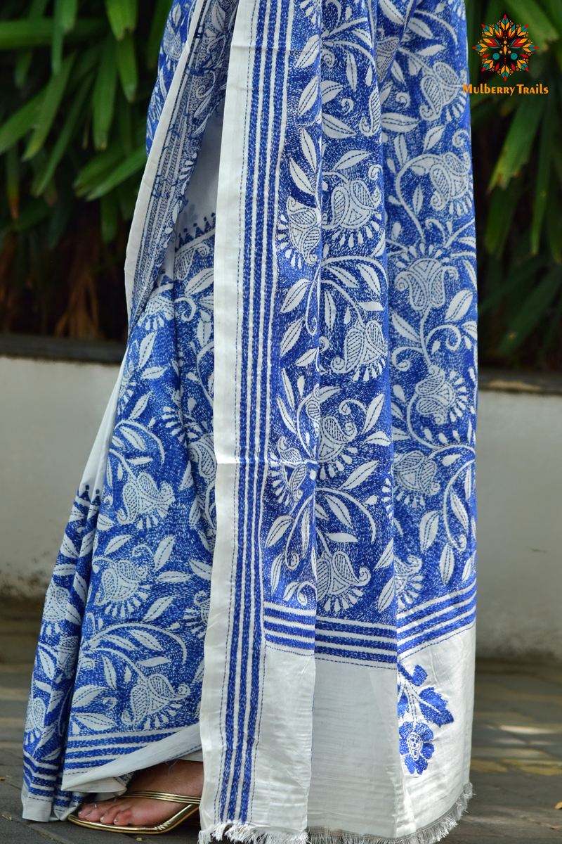 Art Silk saree with intricate Kantha embroidery featuring delicate floral and geometric patterns. The saree has a smooth, lightweight texture with vibrant threads that highlight the traditional hand-embroidery, adding a touch of elegance and cultural charm. Ideal for festive occasions, celebrations, or as a statement piece for special events.