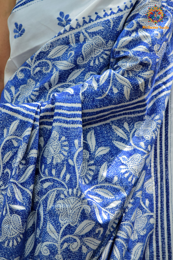 Art Silk saree with intricate Kantha embroidery featuring delicate floral and geometric patterns. The saree has a smooth, lightweight texture with vibrant threads that highlight the traditional hand-embroidery, adding a touch of elegance and cultural charm. Ideal for festive occasions, celebrations, or as a statement piece for special events.