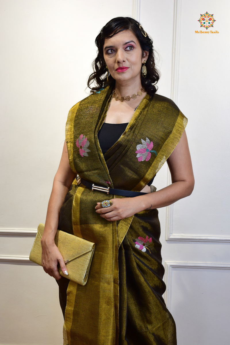 This image features an Elegant tissue saree featuring intricate handwoven Jamdani lotus motifs, with a lightweight, shimmery fabric that drapes beautifully, perfect for festive and special occasions. Party wear , diwali theme. 