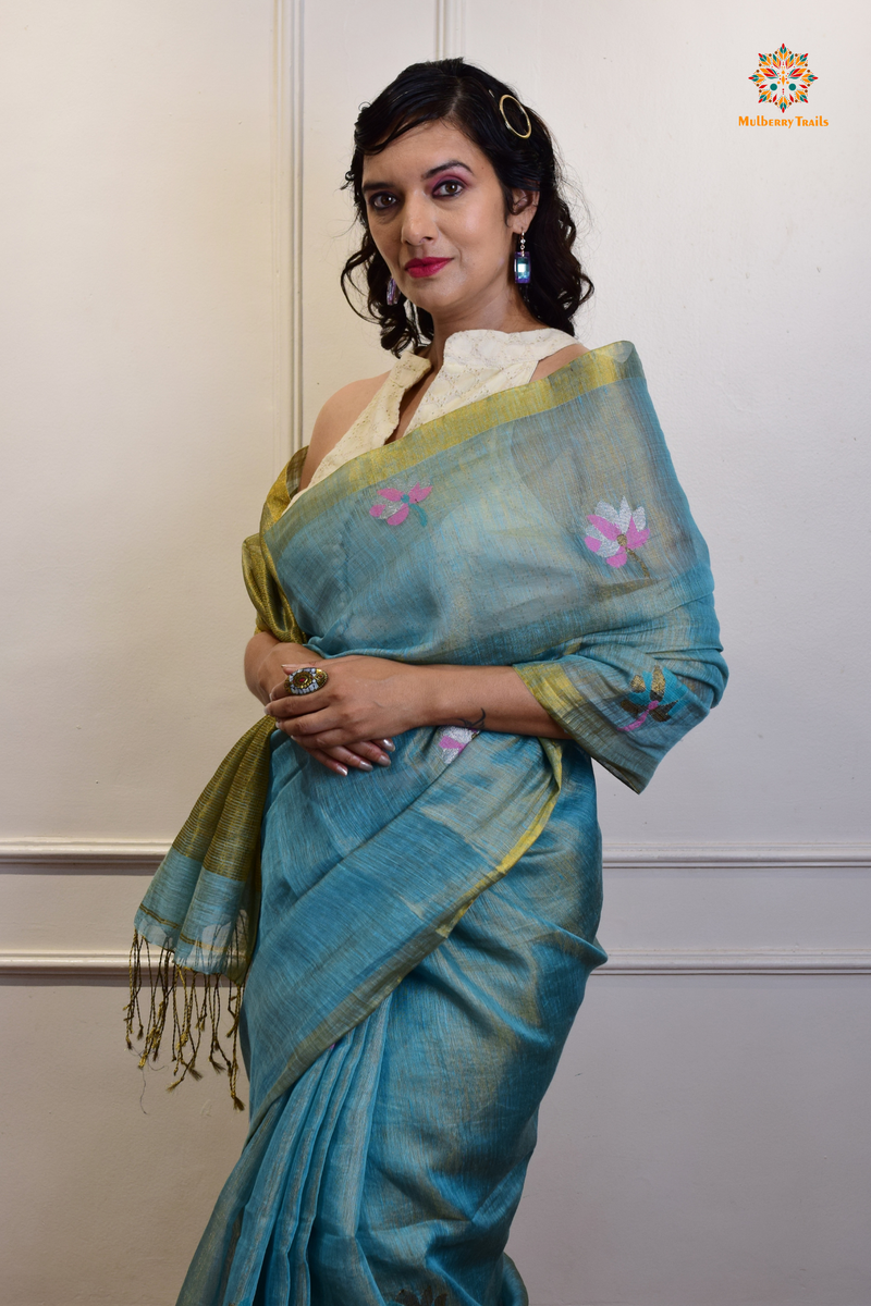 This image features an Elegant tissue saree featuring intricate handwoven Jamdani lotus motifs, with a lightweight, shimmery fabric that drapes beautifully, perfect for festive and special occasions. Party wear , diwali theme. 