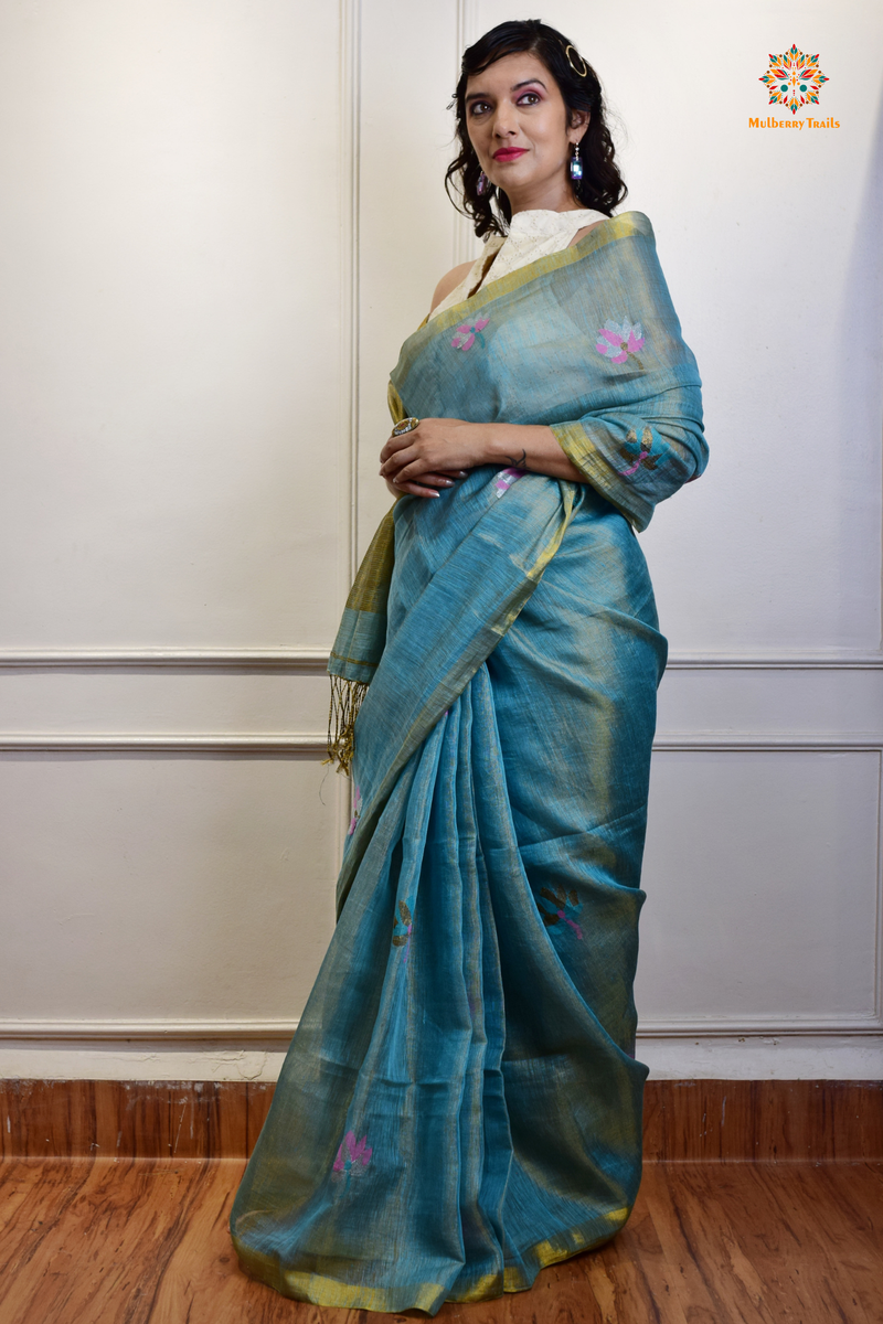 This image features an Elegant tissue saree featuring intricate handwoven Jamdani lotus motifs, with a lightweight, shimmery fabric that drapes beautifully, perfect for festive and special occasions. Party wear , diwali theme. 