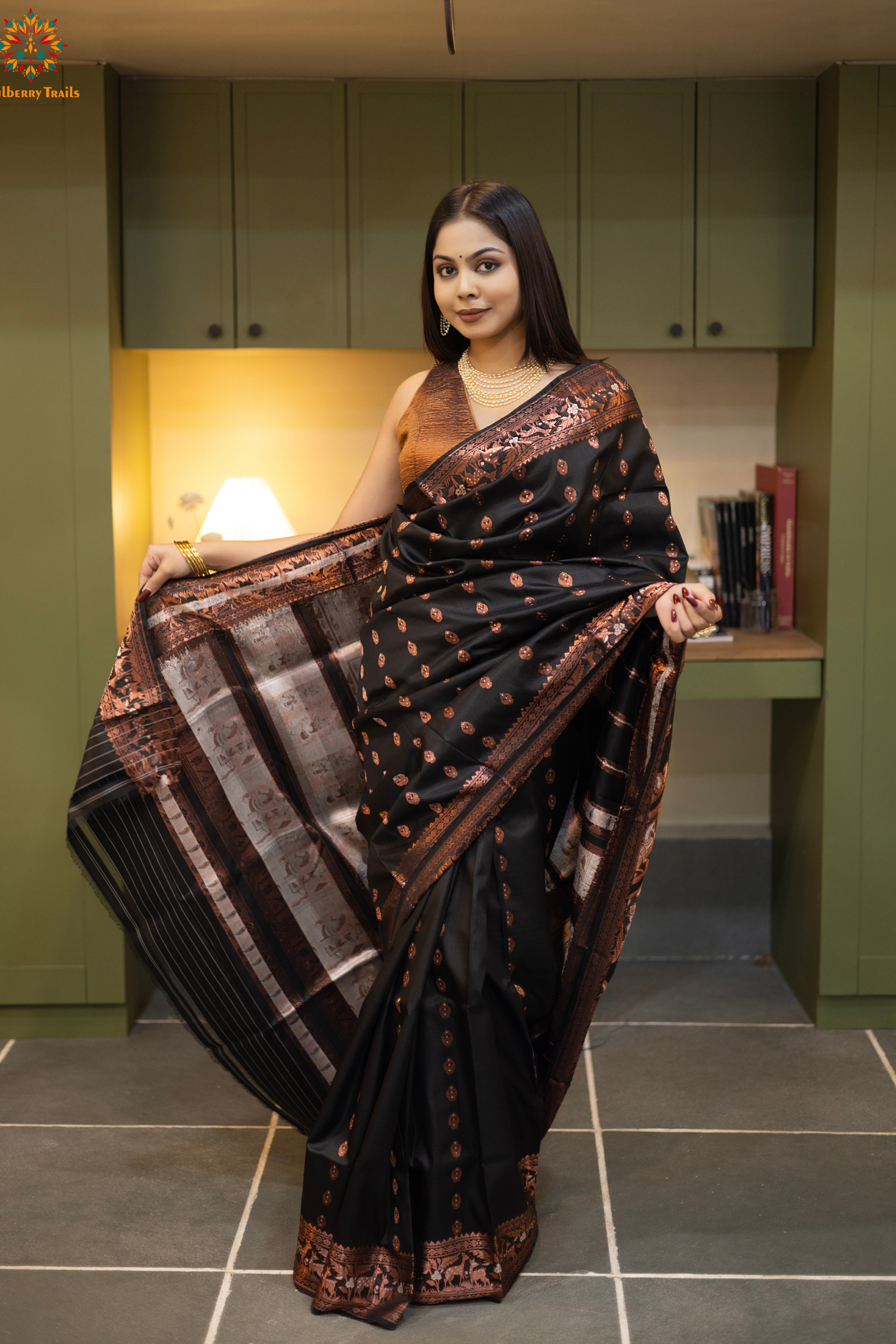 Swarnachari – Pure Silk Hazarbutta Saree

1. “Pure silk Swarnachari saree with hazarbutta thousand-motif weave and copper zari detailing for a regal look.”

2. “Silk Mark pure silk hazarbutta saree featuring intricate copper zari motifs and rich texture.” 
Woman wearing a black and copper zari saree in a room with a desk and lamp.