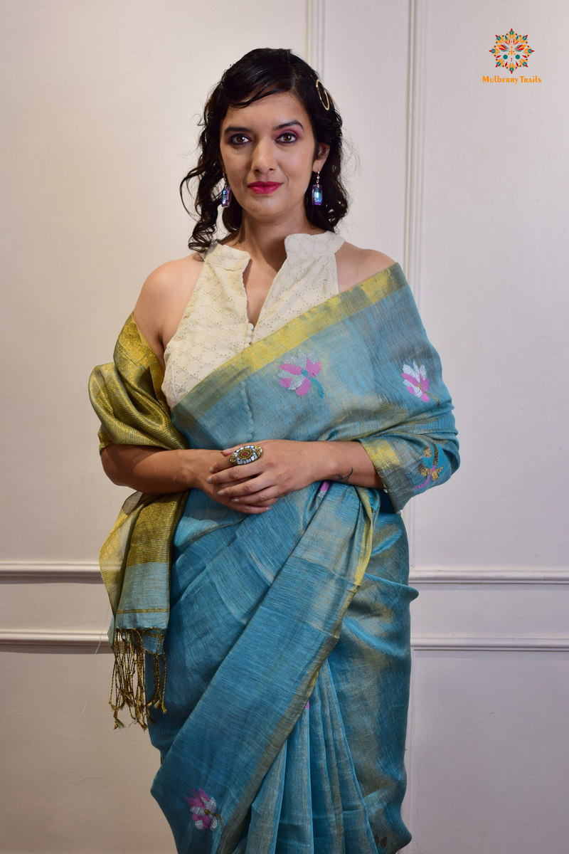 This image features an Elegant tissue saree featuring intricate handwoven Jamdani lotus motifs, with a lightweight, shimmery fabric that drapes beautifully, perfect for festive and special occasions. Party wear , diwali theme. 