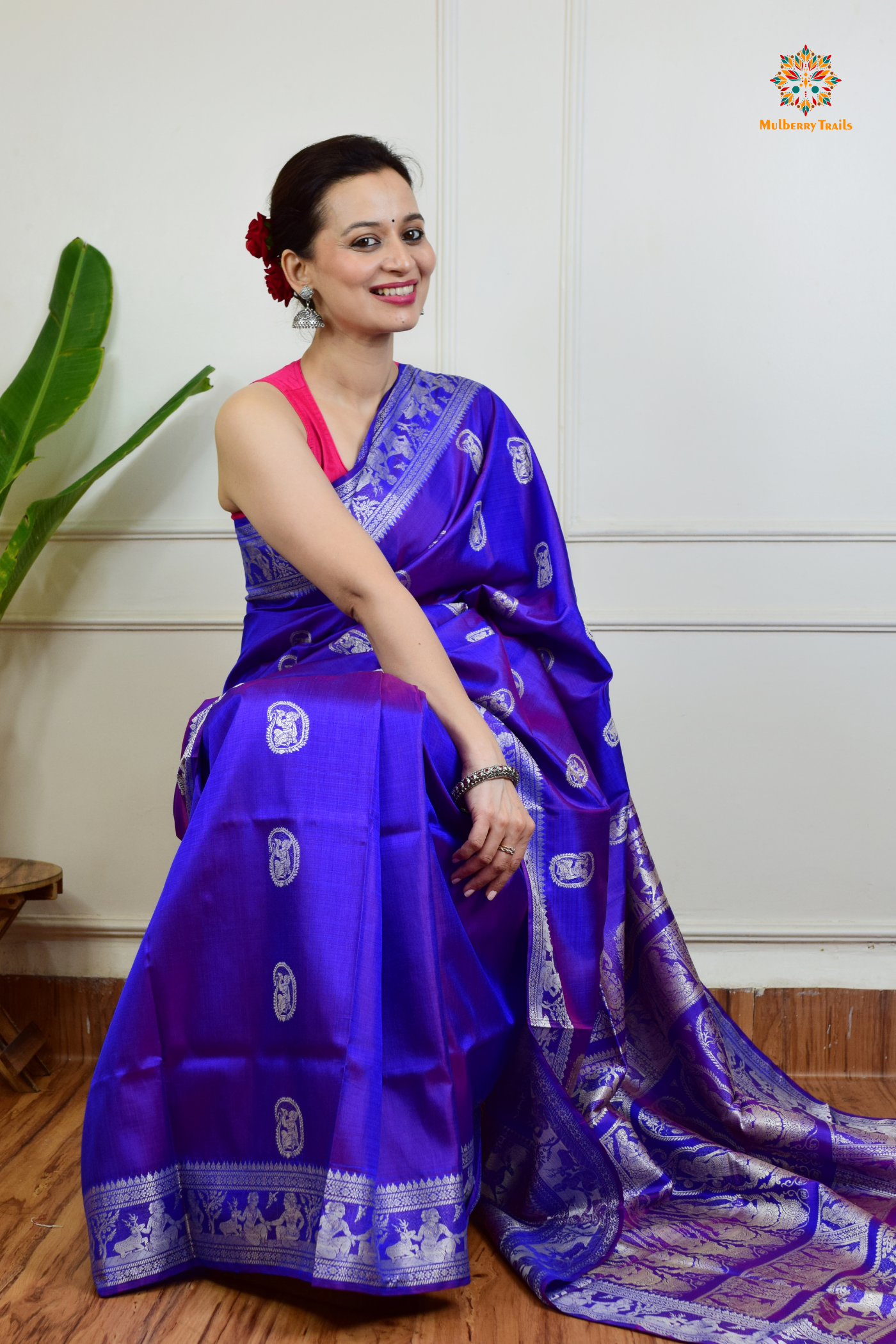 A woman wearing a Purple Baluchari Pure SIlk saree. Purple baluchari silk , bengal silk saree with deer motif on pallu and ramayan, mahabharat motifs on pallu. This is a soft pure silk saree suitable for weddings, parties, festivities. suitable for Durga Puja shopping enthusiasts and diwali festival. 