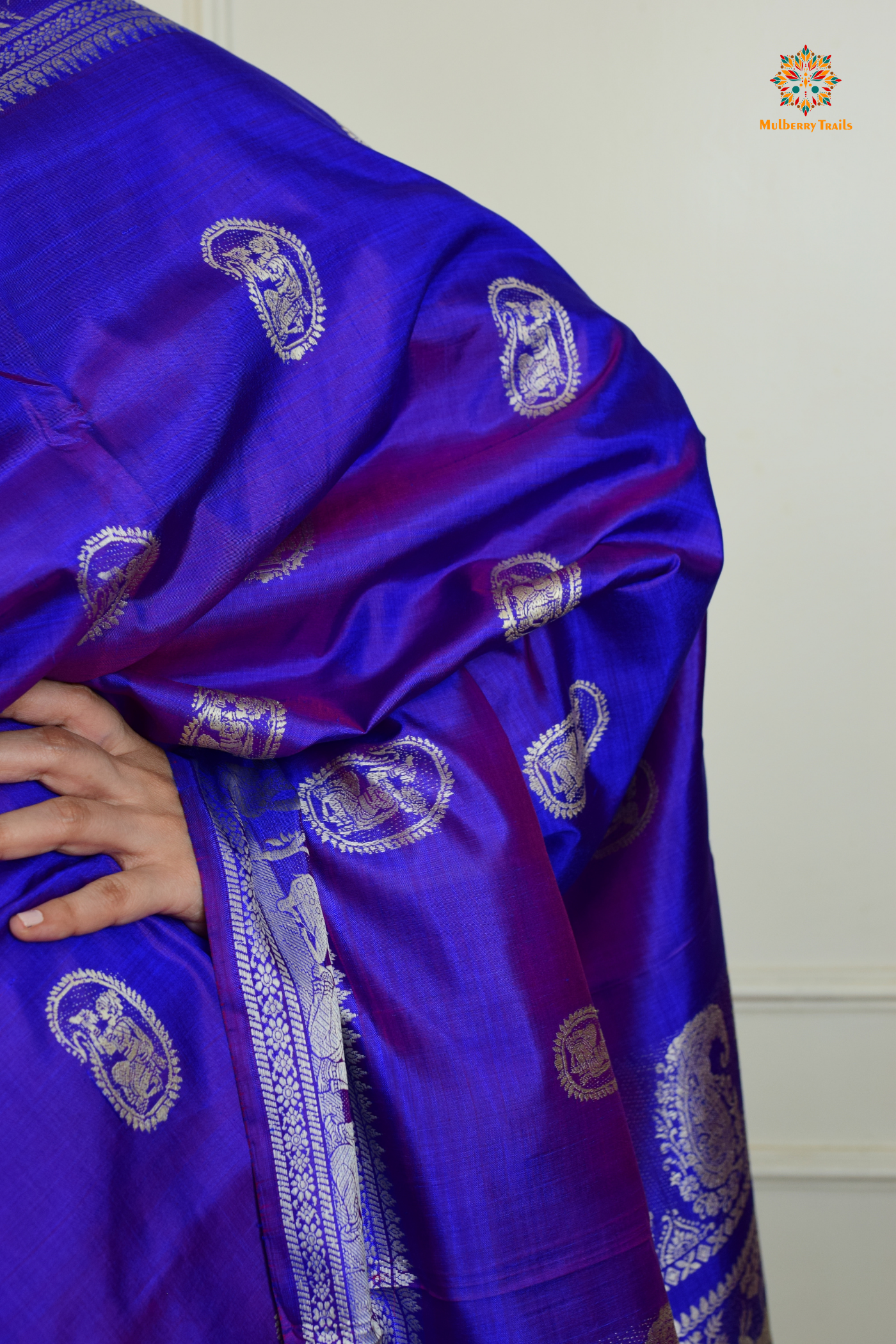 A woman wearing a Purple Baluchari Pure SIlk saree. Purple baluchari silk , bengal silk saree with deer motif on pallu and ramayan, mahabharat motifs on pallu. This is a soft pure silk saree suitable for weddings, parties, festivities. suitable for Durga Puja shopping enthusiasts and diwali festival. 