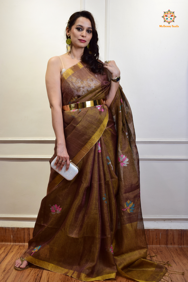 This image features an Elegant tissue saree featuring intricate handwoven Jamdani lotus motifs, with a lightweight, shimmery fabric that drapes beautifully, perfect for festive and special occasions. Party wear , diwali theme. 