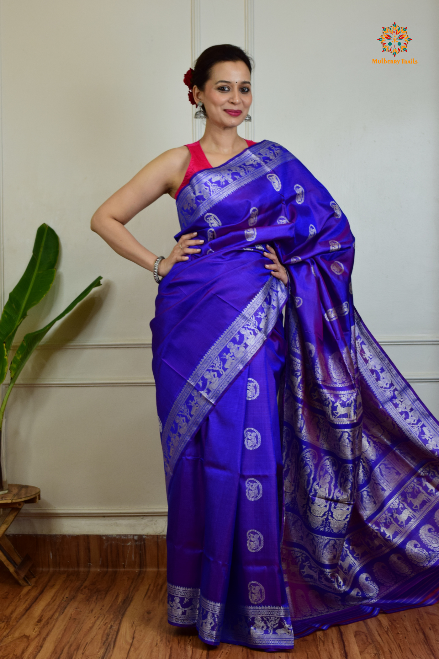 A woman wearing a Purple Baluchari Pure SIlk saree. Purple baluchari silk , bengal silk saree with deer motif on pallu and ramayan, mahabharat motifs on pallu. This is a soft pure silk saree suitable for weddings, parties, festivities. suitable for Durga Puja shopping enthusiasts and diwali festival. 