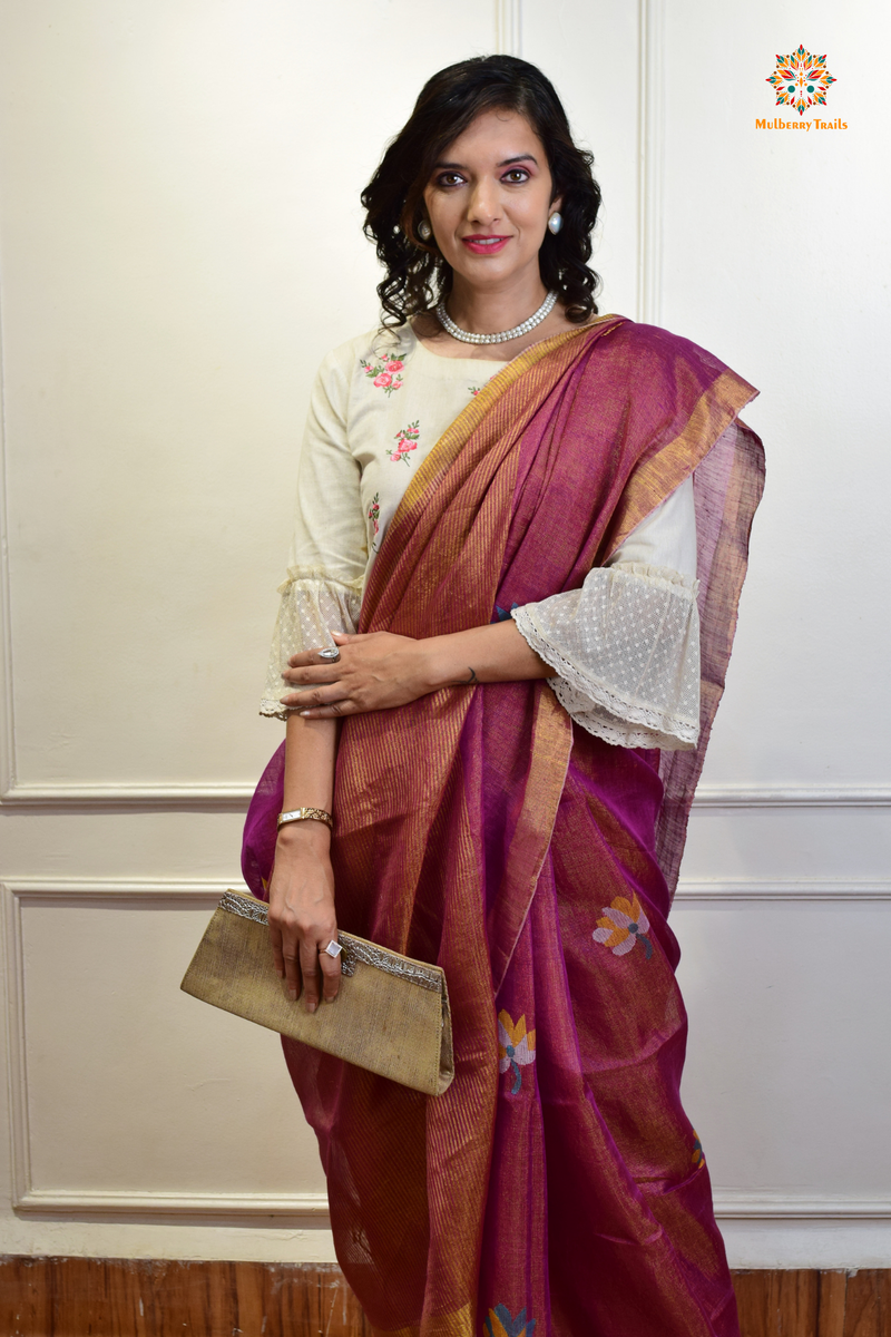 This image features an Elegant tissue saree featuring intricate handwoven Jamdani lotus motifs, with a lightweight, shimmery fabric that drapes beautifully, perfect for festive and special occasions. Party wear , diwali theme. 