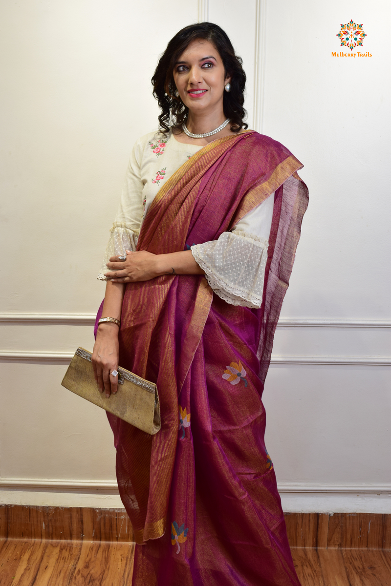 This image features an Elegant tissue saree featuring intricate handwoven Jamdani lotus motifs, with a lightweight, shimmery fabric that drapes beautifully, perfect for festive and special occasions. Party wear , diwali theme. 