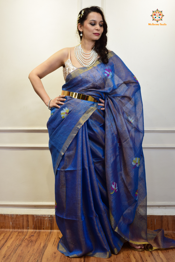 This image features an Elegant tissue saree featuring intricate handwoven Jamdani lotus motifs, with a lightweight, shimmery fabric that drapes beautifully, perfect for festive and special occasions. Party wear , diwali theme. 