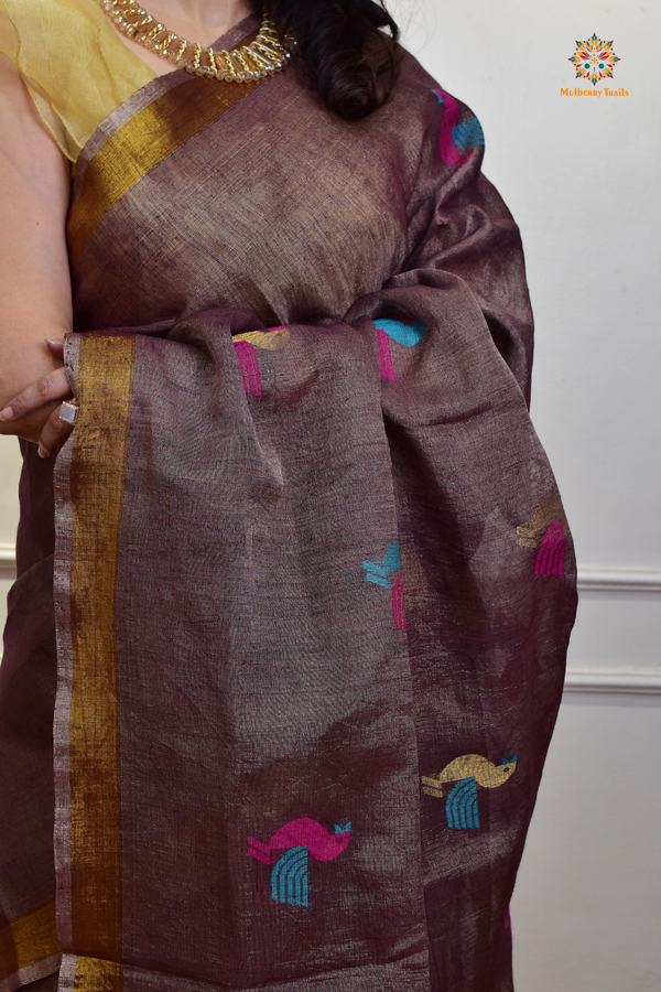 This image features an Elegant tissue saree featuring intricate handwoven Jamdani lotus motifs, with a lightweight, shimmery fabric that drapes beautifully, perfect for festive and special occasions. Party wear , diwali theme. 