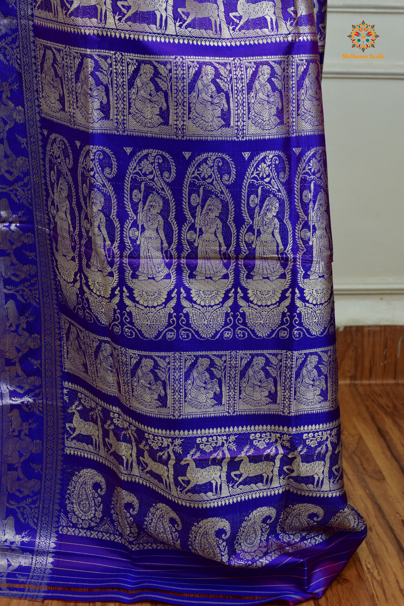 A woman wearing a Purple Baluchari Pure SIlk saree. Purple baluchari silk , bengal silk saree with deer motif on pallu and ramayan, mahabharat motifs on pallu. This is a soft pure silk saree suitable for weddings, parties, festivities. suitable for Durga Puja shopping enthusiasts and diwali festival. 