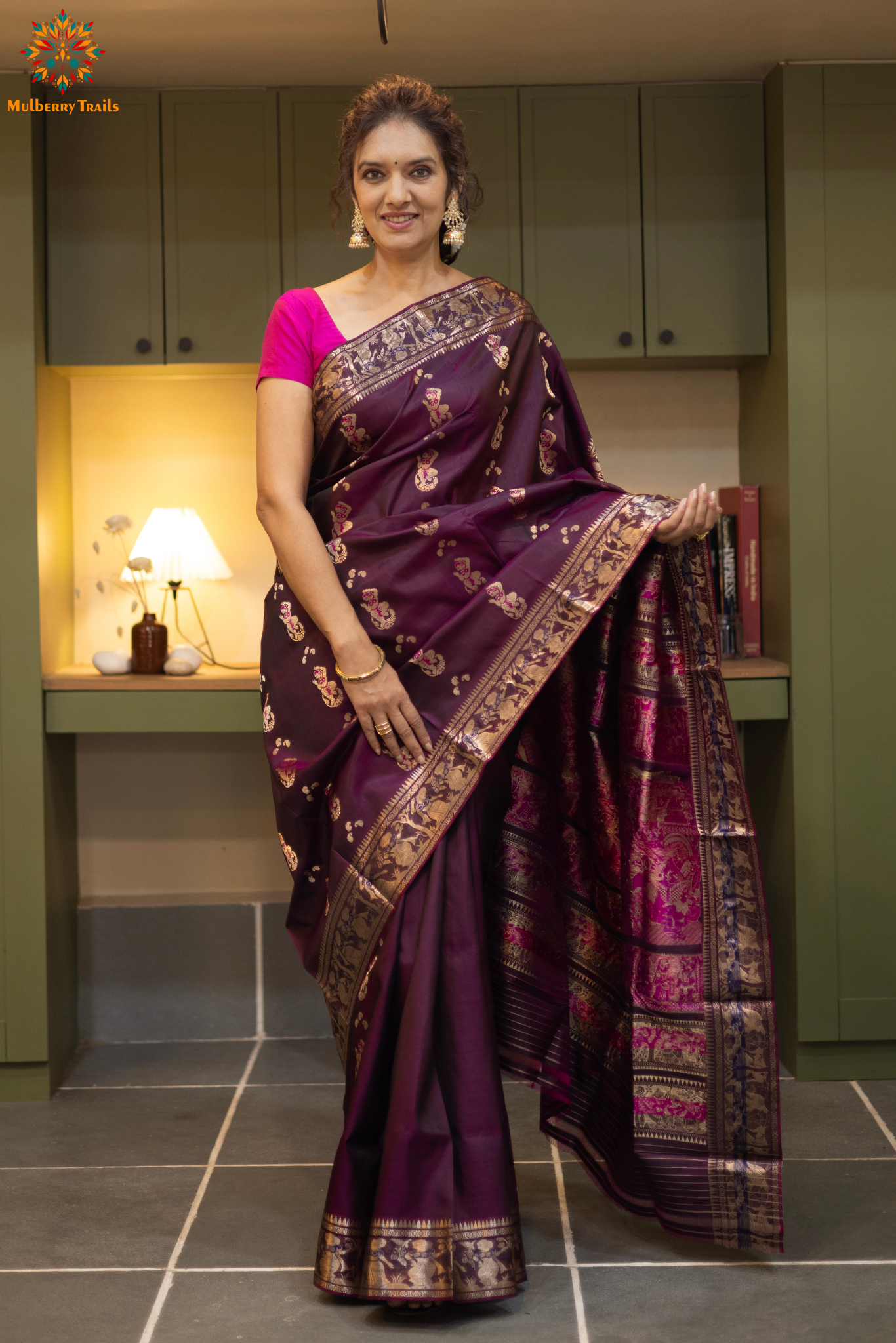 Woman wearing a purple saree with a pattern in a room. Woman in a wine saree standing in a elegant setting. 
Swarnachari – Pure Silk Meenakari Saree

1. “Pure silk Swarnachari saree with meenakari motif weave and gold copper zari detailing for a regal look.”

2. “Silk Mark pure silk meenakari saree featuring intricate copper gold zari motifs and rich texture.” 
Woman wearing a wine color swarnachari saree in a room with a desk and lamp.
