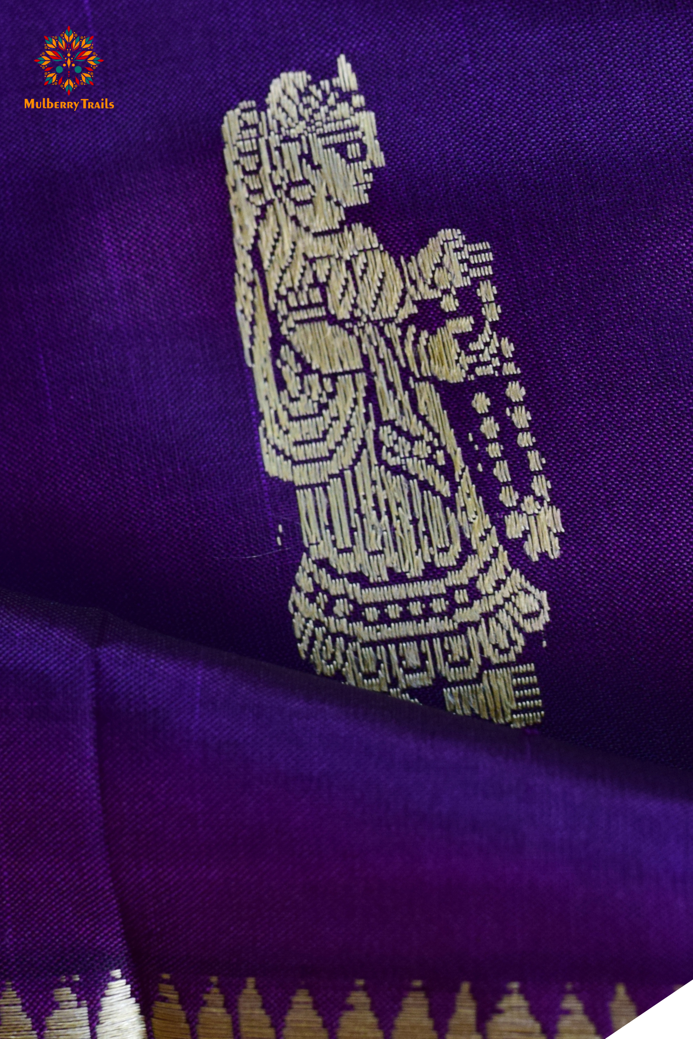 A woman wearing a Purple Baluchari Pure SIlk saree. purple baluchari silk , bengal silk saree with deer motif on pallu and ramayan, mahabharat motifs on pallu. This is a soft pure silk saree suitable for weddings, parties, festivities. suitable for Durga Puja shopping enthusiasts and diwali festival. 