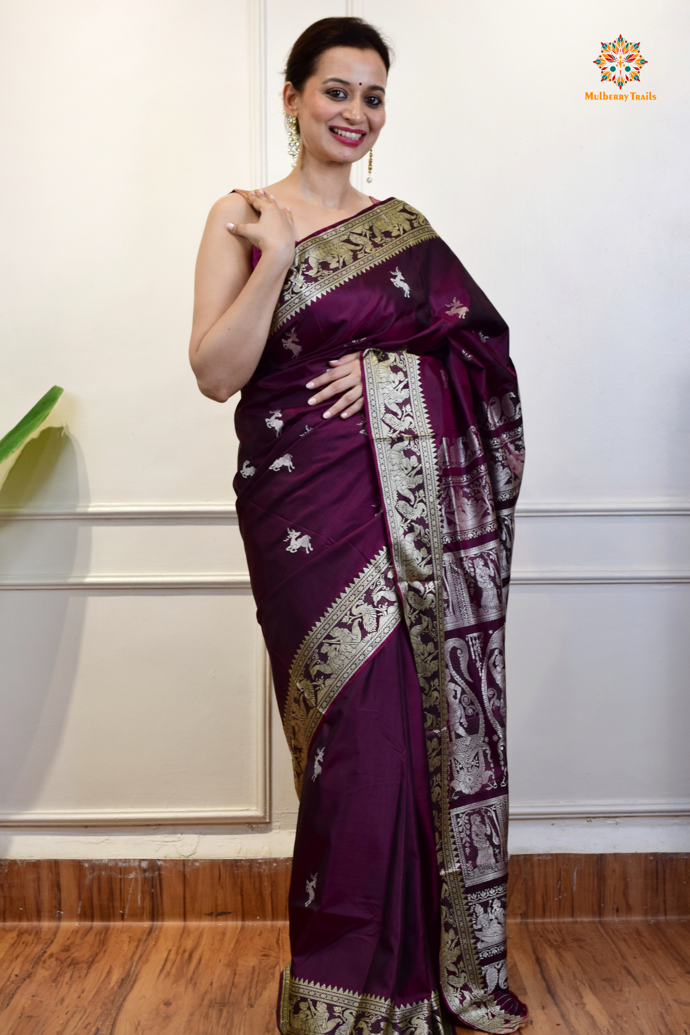 A woman wearing a Purple Baluchari Pure SIlk saree. Purple baluchari silk , bengal silk saree with deer motif on pallu and ramayan, mahabharat motifs on pallu. This is a soft pure silk saree suitable for weddings, parties, festivities. suitable for Durga Puja shopping enthusiasts and diwali festival. 