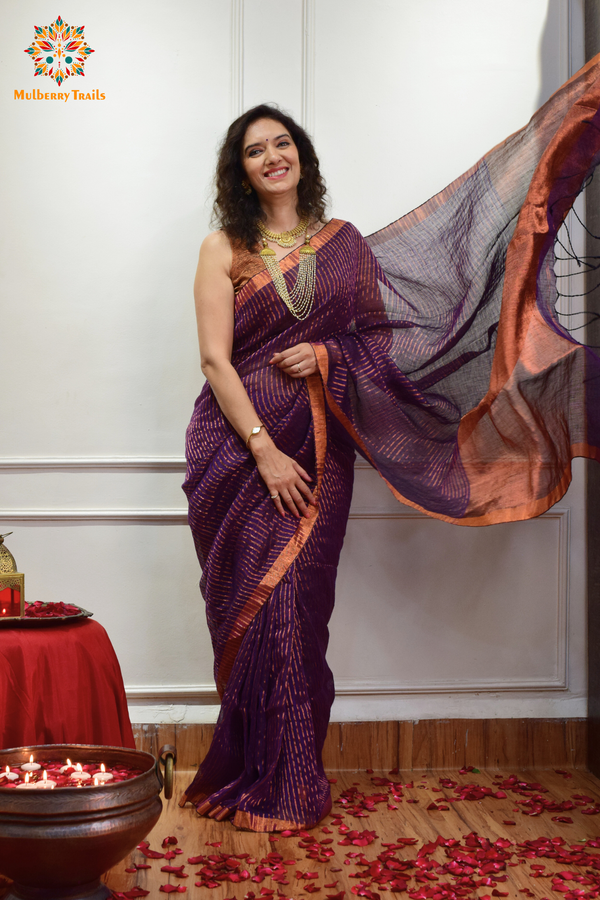 Woman celebrating Indian Festivals draped in Premium Handwoven Linen Saree / Sari. Comfortable and contemporary design of sari is perfect for attending weddings or festivals. Premium saree for festivals, sophisticated saree, Luxury contemporary sari linen saree, handloom, stripes, tissue, unique copper zari work border, Model wearing Linen sari, Saree and blouse combination, saree for friends wedding, saree for wedding gift, saree for festive wear, sari for ganpati occassion, saree for diwali