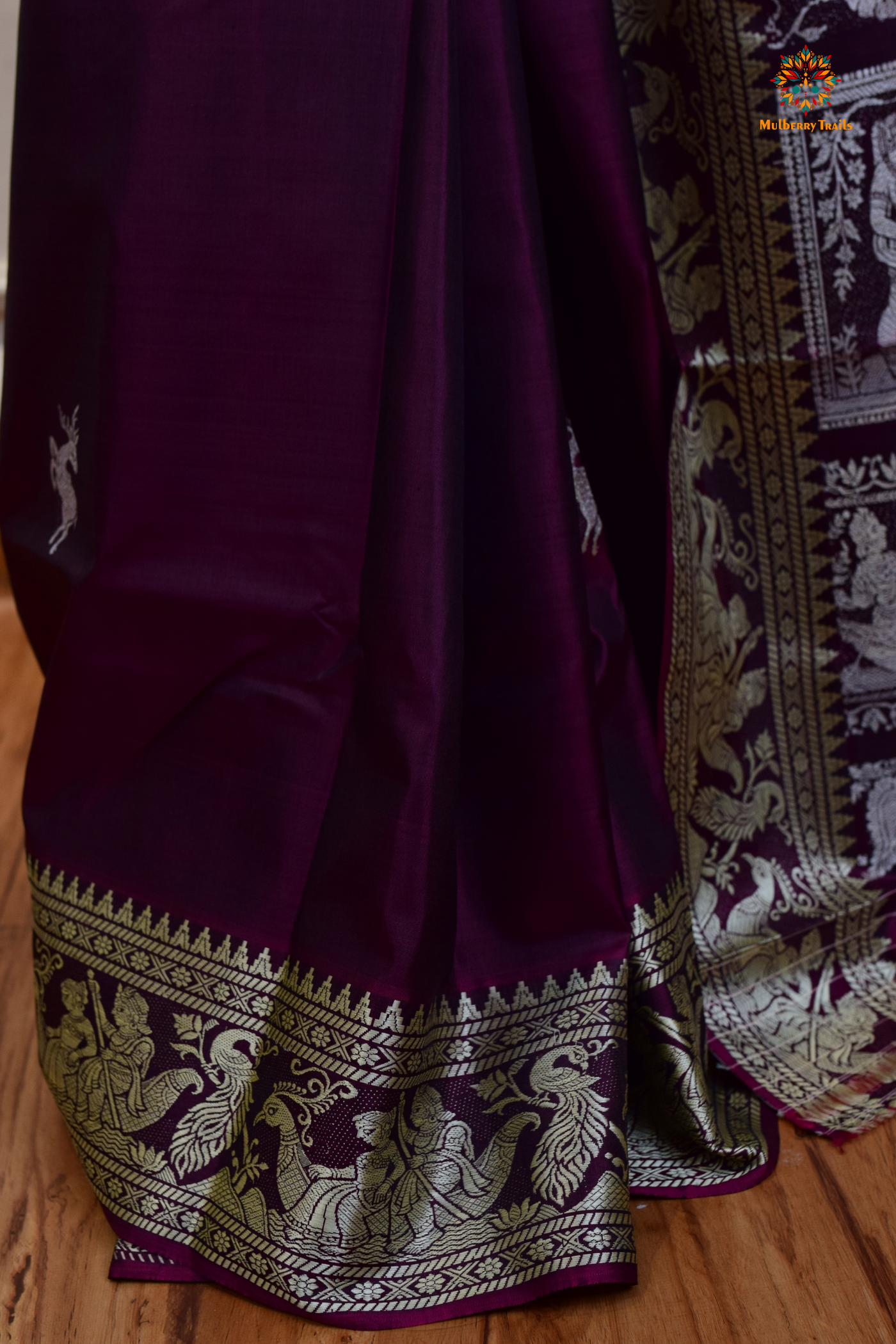 A woman wearing a Purple Baluchari Pure SIlk saree. Purple baluchari silk , bengal silk saree with deer motif on pallu and ramayan, mahabharat motifs on pallu. This is a soft pure silk saree suitable for weddings, parties, festivities. suitable for Durga Puja shopping enthusiasts and diwali festival. 