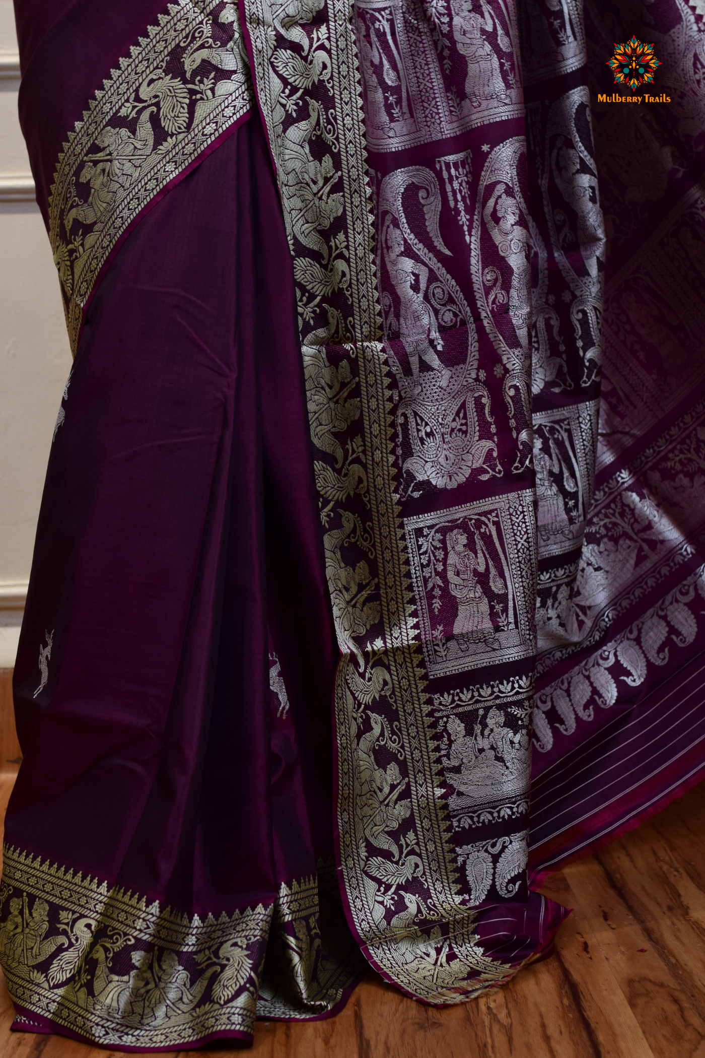 A woman wearing a Purple Baluchari Pure SIlk saree. Purple baluchari silk , bengal silk saree with deer motif on pallu and ramayan, mahabharat motifs on pallu. This is a soft pure silk saree suitable for weddings, parties, festivities. suitable for Durga Puja shopping enthusiasts and diwali festival. 