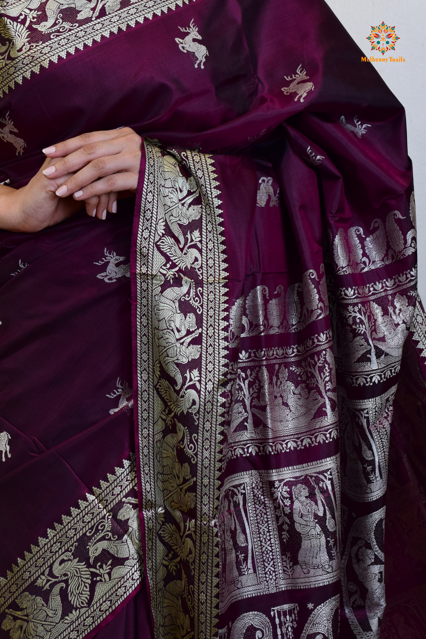 A woman wearing a Purple Baluchari Pure SIlk saree. Purple baluchari silk , bengal silk saree with deer motif on pallu and ramayan, mahabharat motifs on pallu. This is a soft pure silk saree suitable for weddings, parties, festivities. suitable for Durga Puja shopping enthusiasts and diwali festival. 