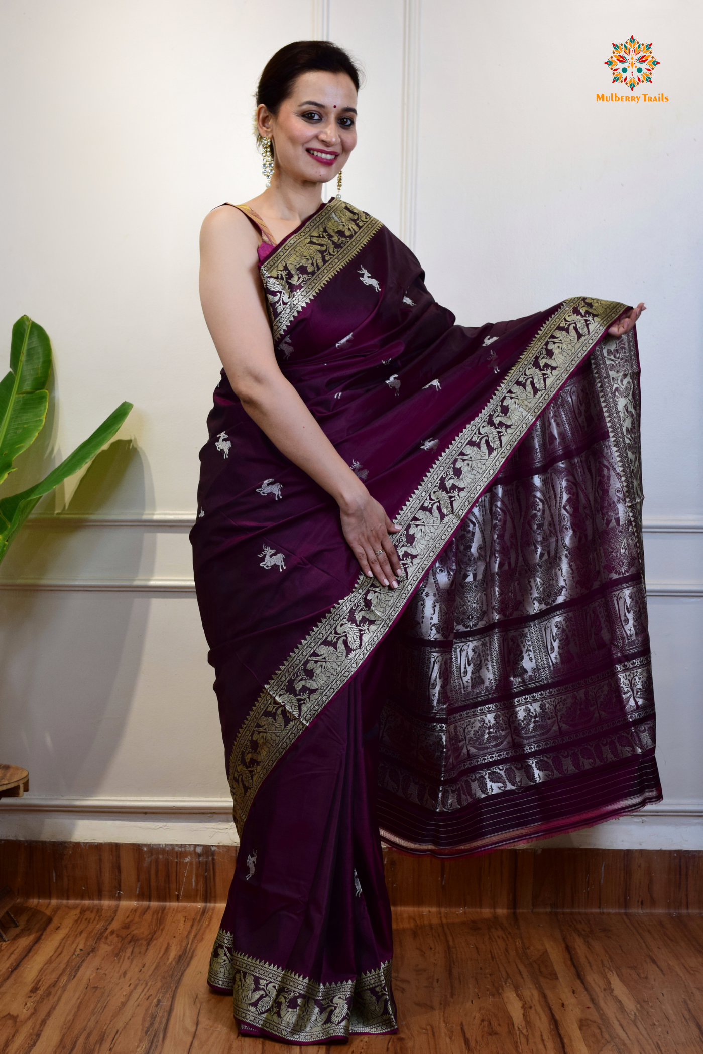 A woman wearing a Purple Baluchari Pure SIlk saree. Purple baluchari silk , bengal silk saree with deer motif on pallu and ramayan, mahabharat motifs on pallu. This is a soft pure silk saree suitable for weddings, parties, festivities. suitable for Durga Puja shopping enthusiasts and diwali festival. 