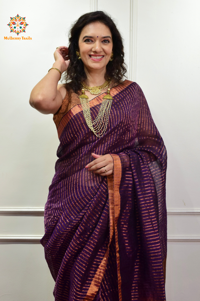 Woman celebrating Indian Festivals draped in Premium Handwoven Linen Saree / Sari. Comfortable and contemporary design of sari is perfect for attending weddings or festivals. Premium saree for festivals, sophisticated saree, Luxury contemporary sari linen saree, handloom, stripes, tissue, unique copper zari work border, Model wearing Linen sari, Saree and blouse combination, saree for friends wedding, saree for wedding gift, saree for festive wear, sari for ganpati occassion, saree for diwali