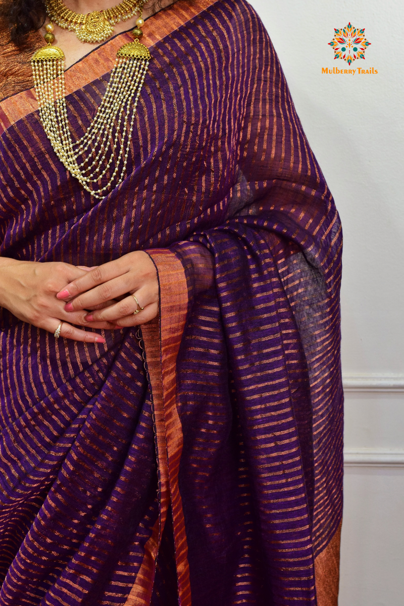 Woman celebrating Indian Festivals draped in Premium Handwoven Linen Saree / Sari. Comfortable and contemporary design of sari is perfect for attending weddings or festivals. Premium saree for festivals, sophisticated saree, Luxury contemporary sari linen saree, handloom, stripes, tissue, unique copper zari work border, Model wearing Linen sari, Saree and blouse combination, saree for friends wedding, saree for wedding gift, saree for festive wear, sari for ganpati occassion, saree for diwali