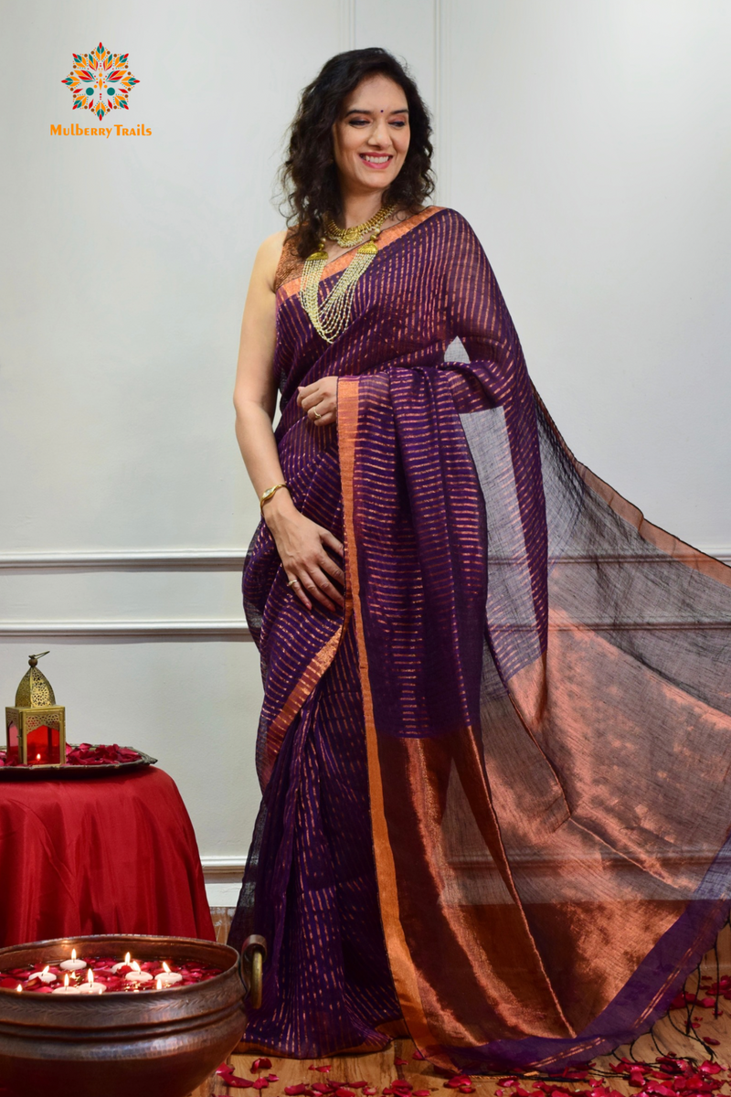 Woman celebrating Indian Festivals draped in Premium Handwoven Linen Saree / Sari. Comfortable and contemporary design of sari is perfect for attending weddings or festivals. Premium saree for festivals, sophisticated saree, Luxury contemporary sari linen saree, handloom, stripes, tissue, unique copper zari work border, Model wearing Linen sari, Saree and blouse combination, saree for friends wedding, saree for wedding gift, saree for festive wear, sari for ganpati occassion, saree for diwali