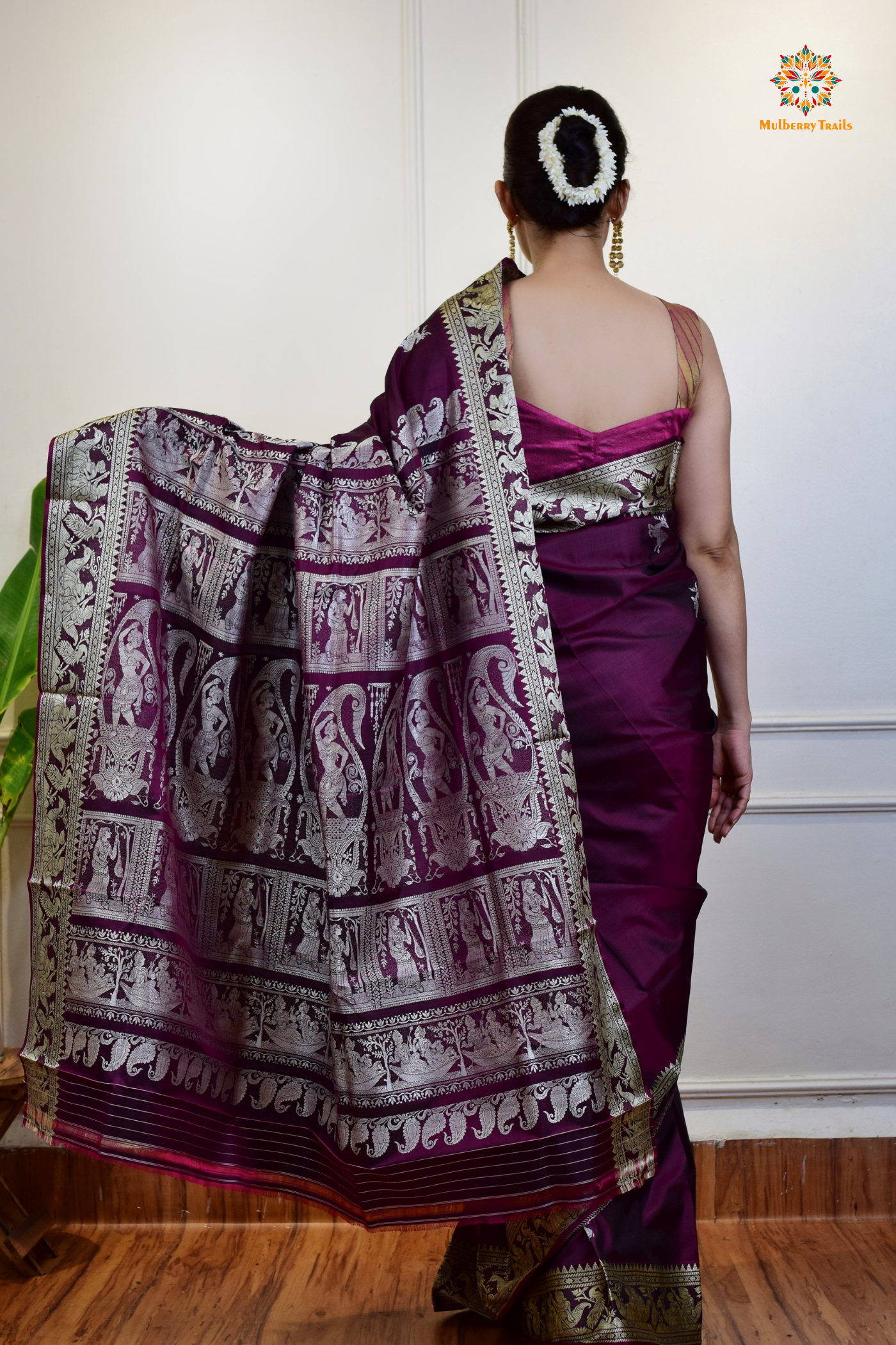 A woman wearing a Purple Baluchari Pure SIlk saree. Purple baluchari silk , bengal silk saree with deer motif on pallu and ramayan, mahabharat motifs on pallu. This is a soft pure silk saree suitable for weddings, parties, festivities. suitable for Durga Puja shopping enthusiasts and diwali festival. 