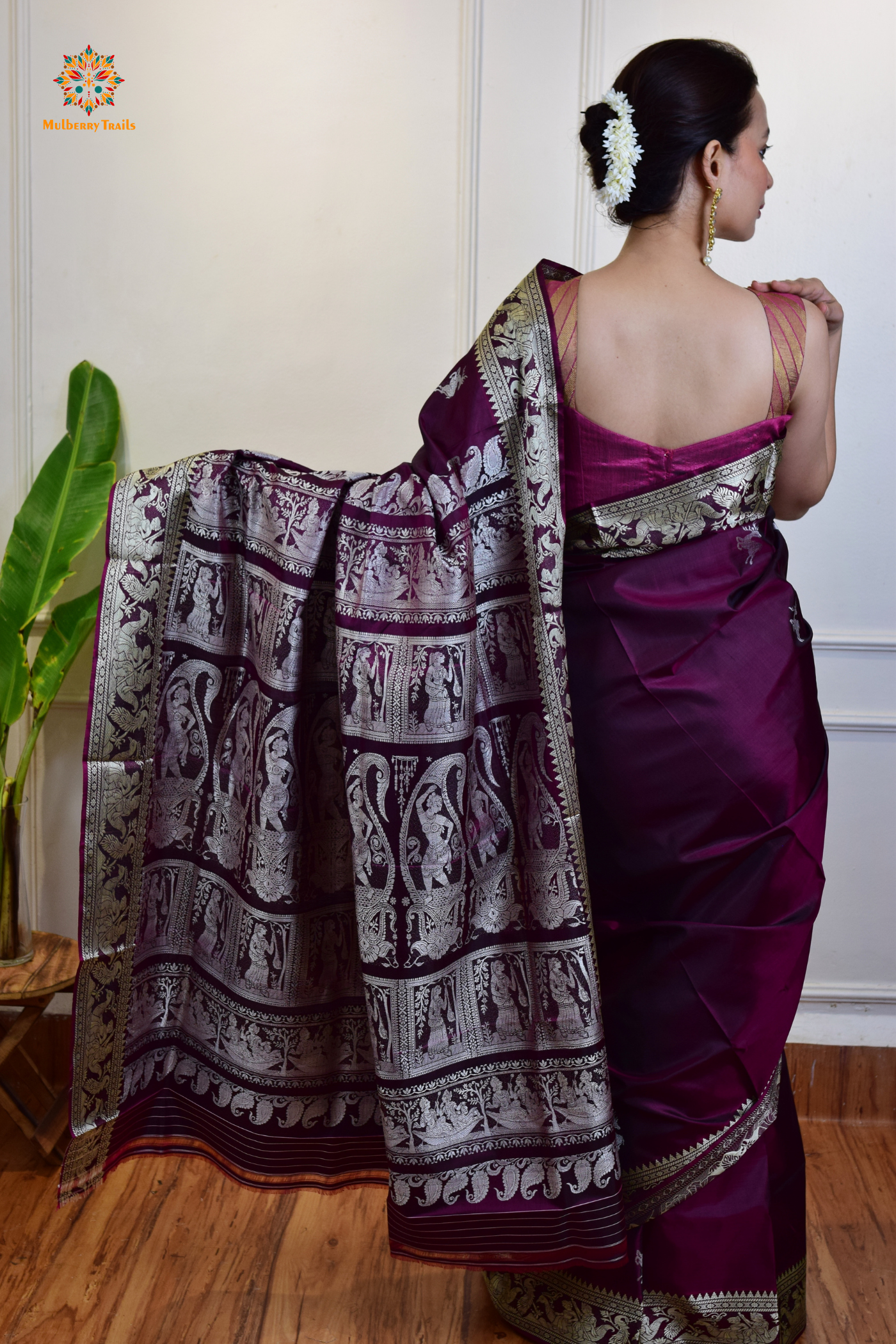 A woman wearing a Purple Baluchari Pure SIlk saree. Purple baluchari silk , bengal silk saree with deer motif on pallu and ramayan, mahabharat motifs on pallu. This is a soft pure silk saree suitable for weddings, parties, festivities. suitable for Durga Puja shopping enthusiasts and diwali festival. 