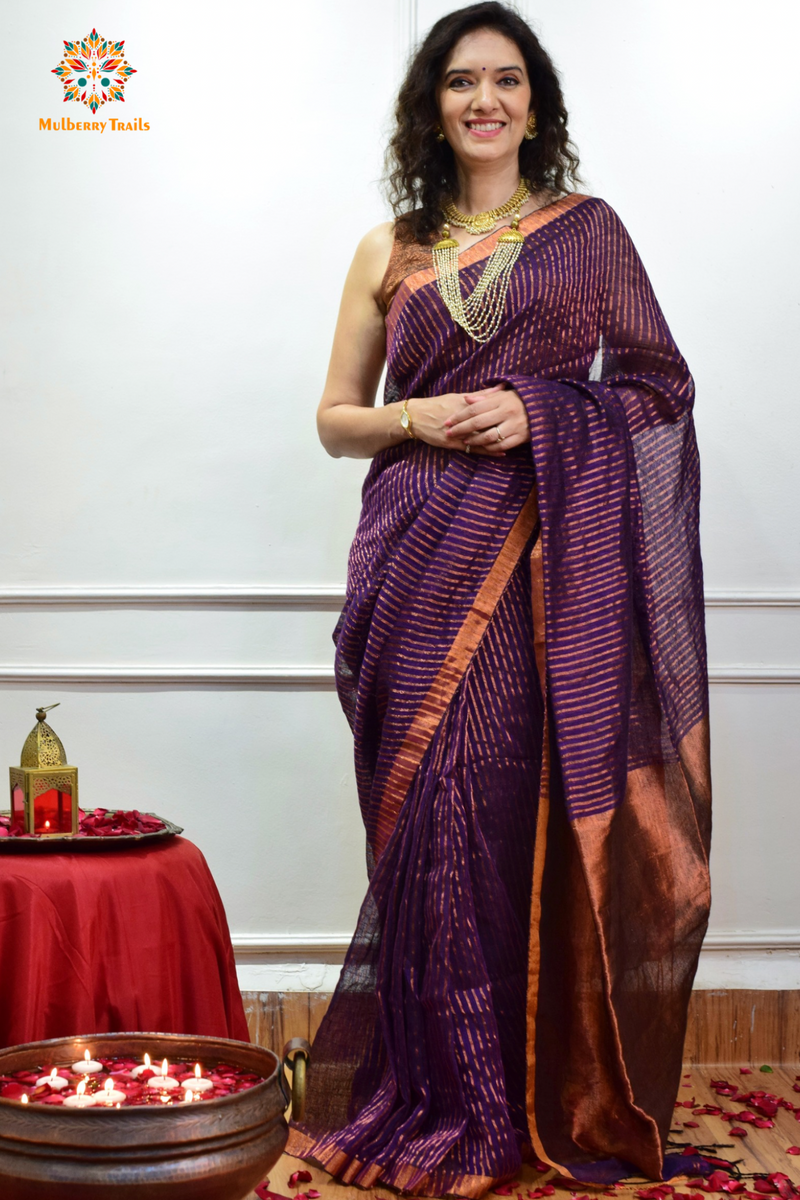 Woman celebrating Indian Festivals draped in Premium Handwoven Linen Saree / Sari. Comfortable and contemporary design of sari is perfect for attending weddings or festivals. Premium saree for festivals, sophisticated saree, Luxury contemporary sari linen saree, handloom, stripes, tissue, unique copper zari work border, Model wearing Linen sari, Saree and blouse combination, saree for friends wedding, saree for wedding gift, saree for festive wear, sari for ganpati occassion, saree for diwali