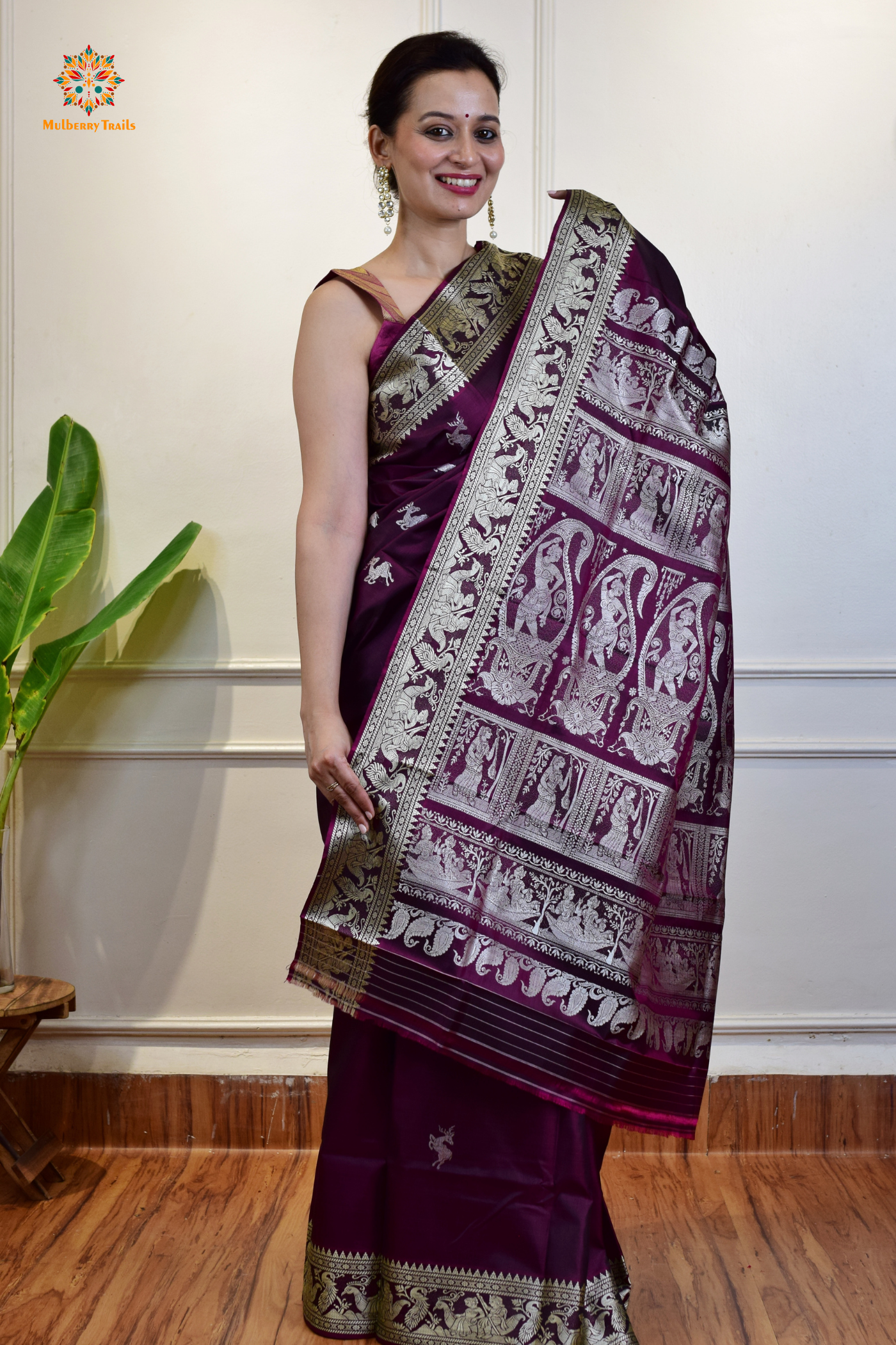 A woman wearing a Purple Baluchari Pure SIlk saree. Purple baluchari silk , bengal silk saree with deer motif on pallu and ramayan, mahabharat motifs on pallu. This is a soft pure silk saree suitable for weddings, parties, festivities. suitable for Durga Puja shopping enthusiasts and diwali festival. 