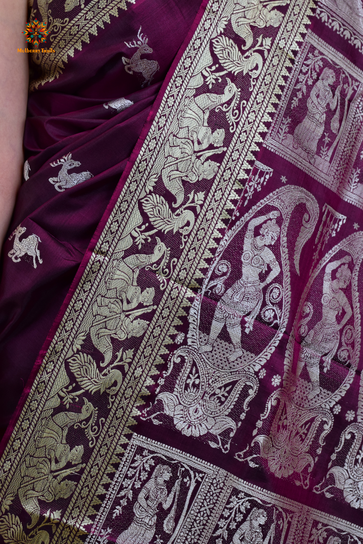 A woman wearing a Purple Baluchari Pure SIlk saree. Purple baluchari silk , bengal silk saree with deer motif on pallu and ramayan, mahabharat motifs on pallu. This is a soft pure silk saree suitable for weddings, parties, festivities. suitable for Durga Puja shopping enthusiasts and diwali festival. 