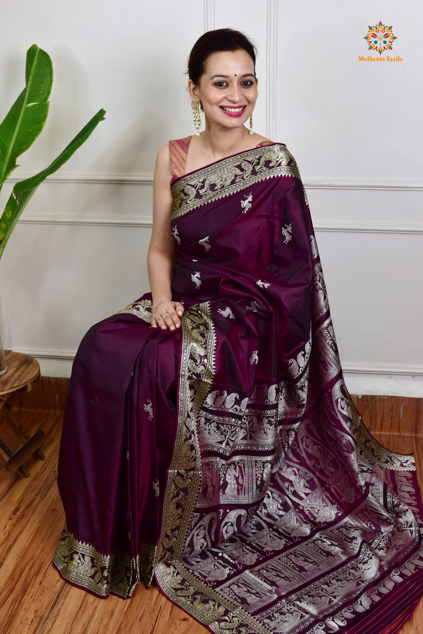 A woman wearing a Purple Baluchari Pure SIlk saree. Purple baluchari silk , bengal silk saree with deer motif on pallu and ramayan, mahabharat motifs on pallu. This is a soft pure silk saree suitable for weddings, parties, festivities. suitable for Durga Puja shopping enthusiasts and diwali festival. 